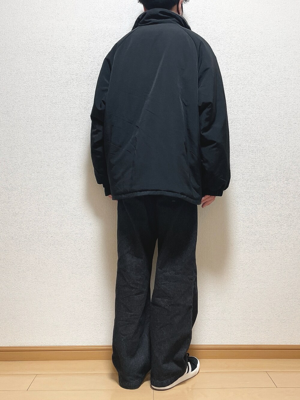 ブラック系のその他アウター、ブラック系のニット/セーター、ブラック系のデニムパンツを着用したメンズの冬コーディネートの4枚目の写真