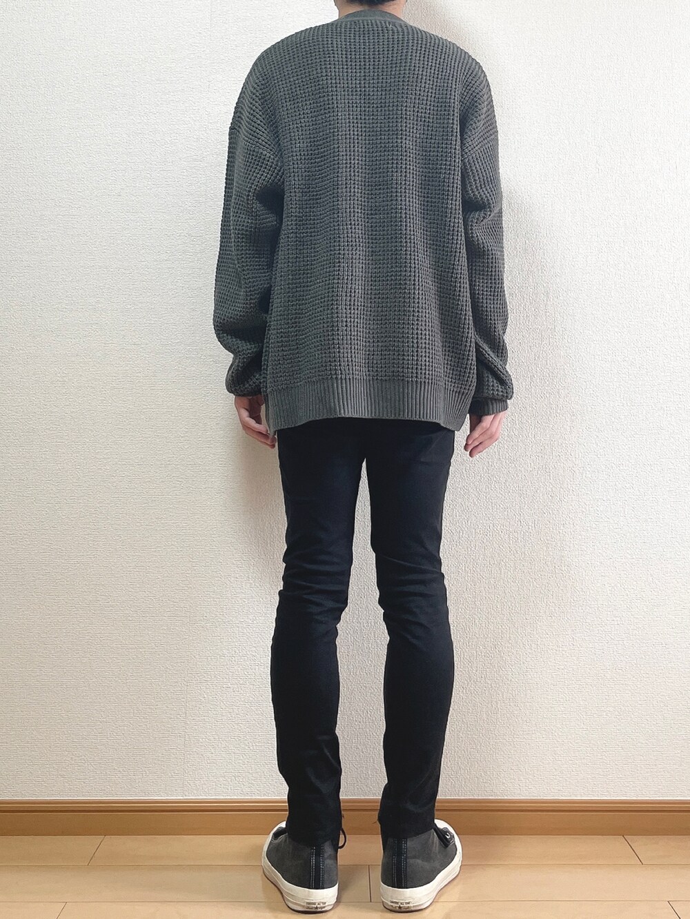 グレー系のカーディガン/ボレロ、ホワイト系のTシャツ/カットソー、ブラック系のデニムパンツを着用したメンズの秋コーディネートの4枚目の写真