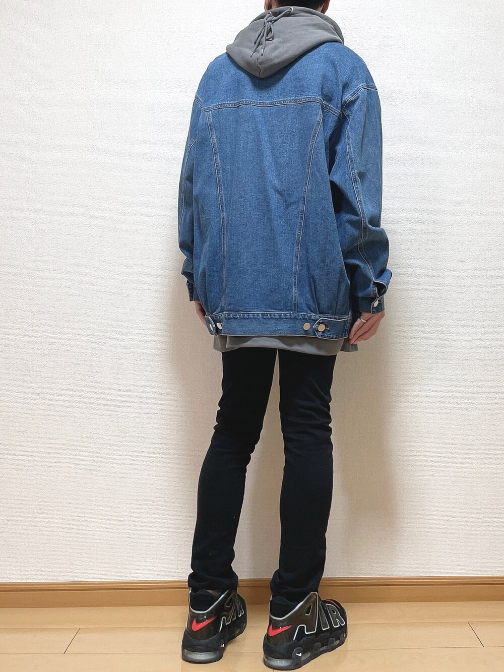 ブルー系のデニムジャケット、グレー系のパーカー、ブラック系のデニムパンツを着用したメンズの春コーディネートの4枚目の写真