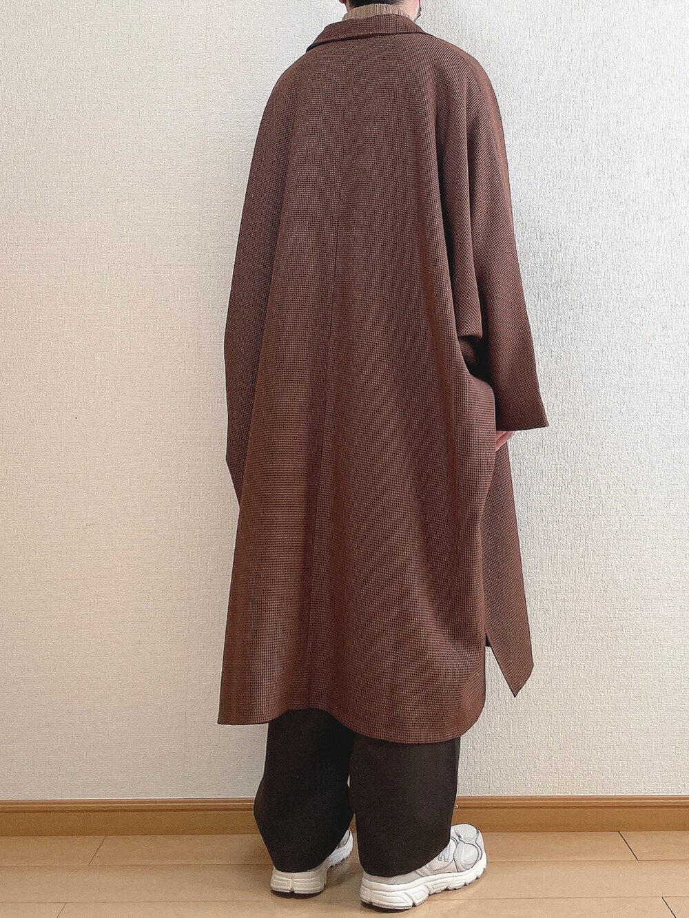 ブラウン系のステンカラーコート、ベージュ系のニット/セーター、ブラウン系のスラックスを着用したメンズの冬コーディネートの4枚目の写真