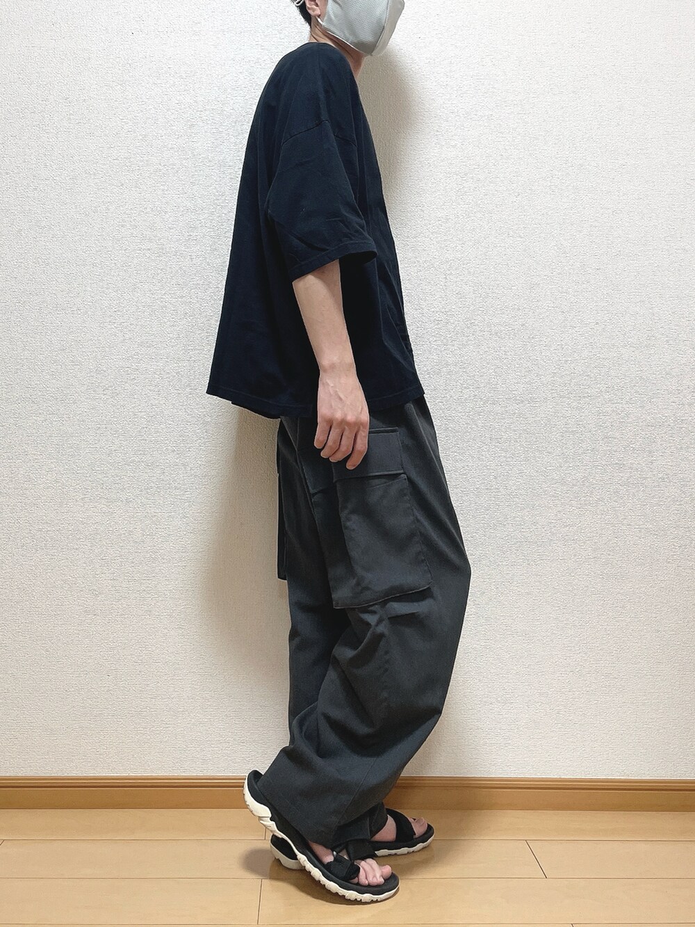 ブラック系のTシャツ/カットソー、グレー系のカーゴパンツ、ブラック系のサンダルを着用したメンズの夏コーディネートの2枚目の写真
