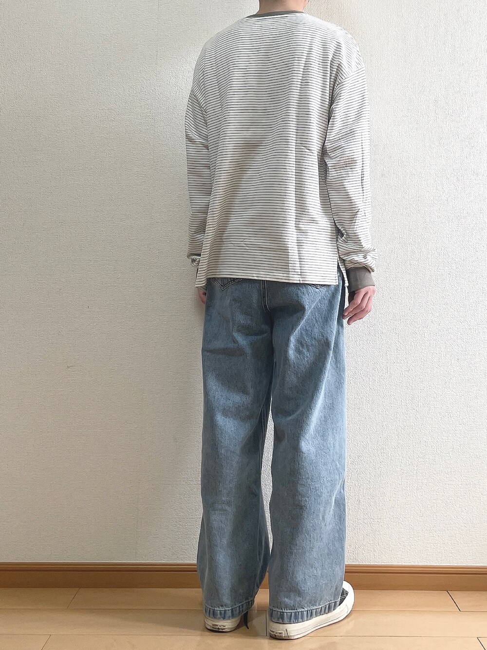 グリーン系のTシャツ/カットソー、ブルー系のデニムパンツ、ブラック系のスニーカーを着用したメンズの春コーディネートの4枚目の写真