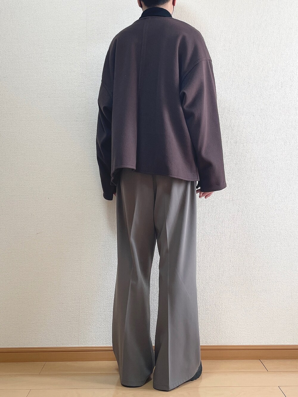 レッド系のブルゾン、ホワイト系のTシャツ/カットソー、ブラウン系のスラックスを着用したメンズの春コーディネートの4枚目の写真