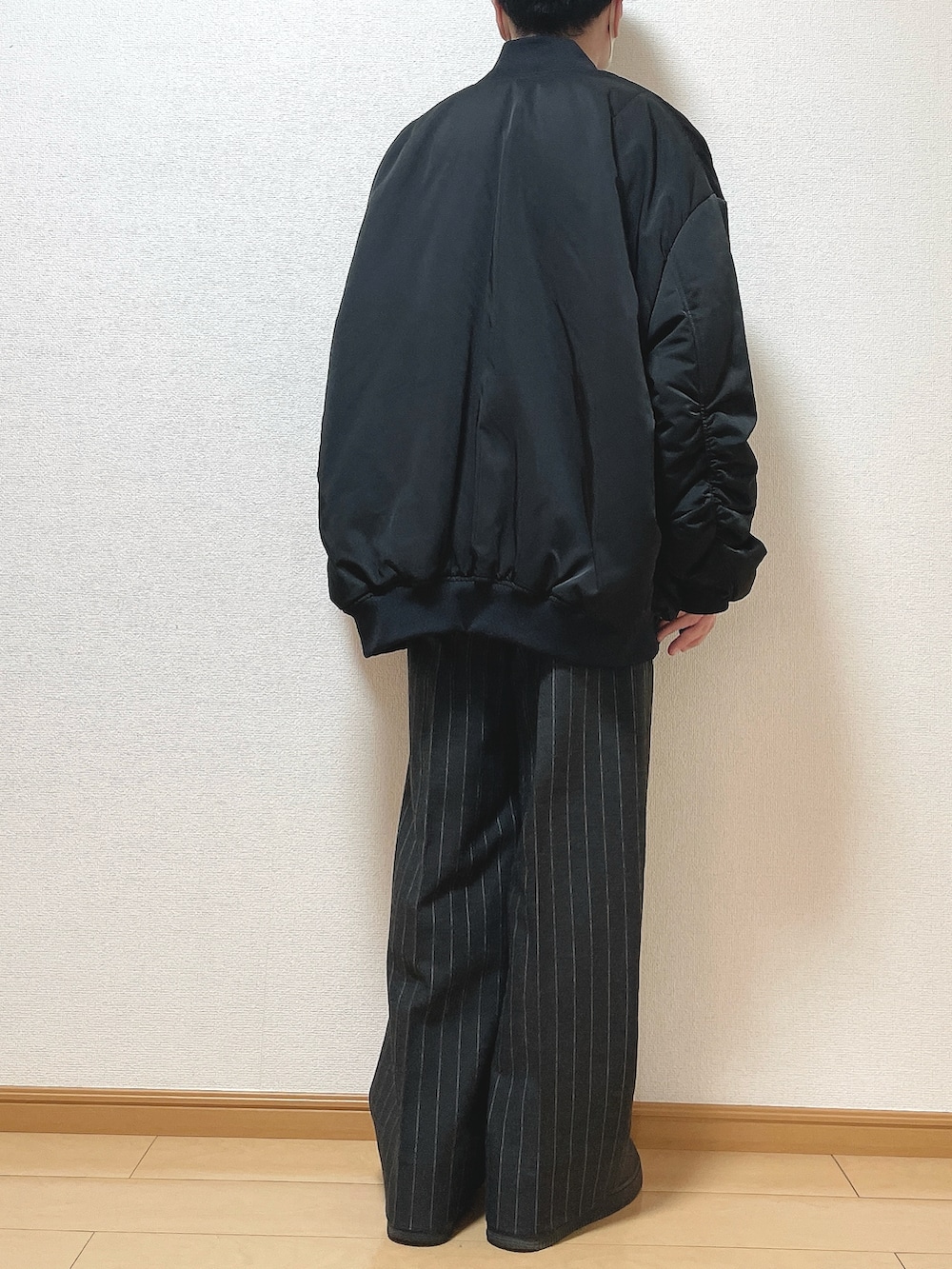 ブラック系のMA-1、ブラウン系のニット/セーター、ブラック系のパンツを着用したメンズの冬コーディネートの4枚目の写真