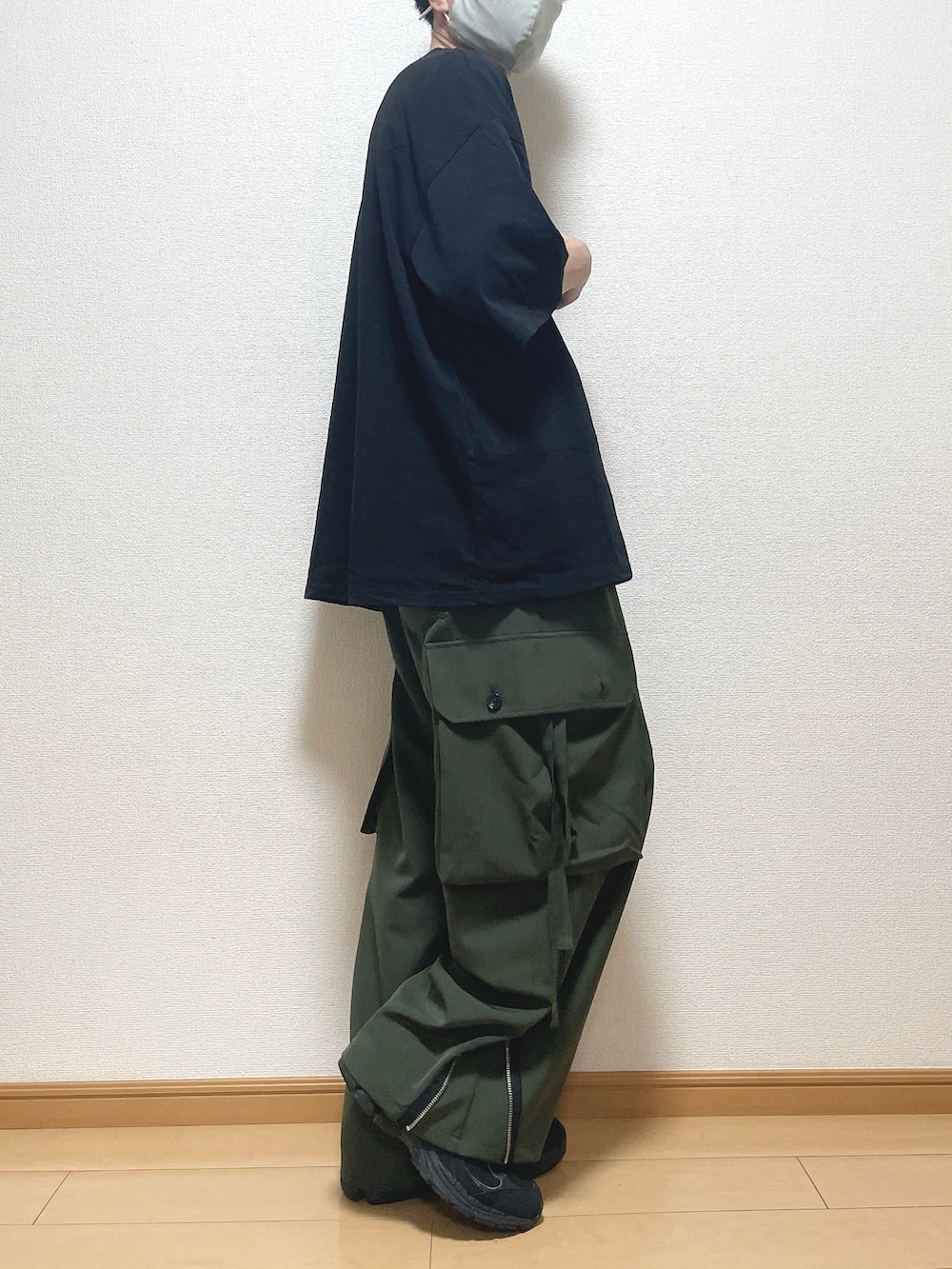 ブラック系のTシャツ/カットソー、グリーン系のカーゴパンツ、ブラック系のスニーカーを着用したメンズの夏コーディネートの2枚目の写真