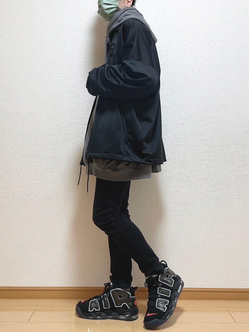 ブラック系のブルゾン、グレー系のパーカー、ホワイト系のTシャツ/カットソーを着用したメンズの冬コーディネートの2枚目の写真