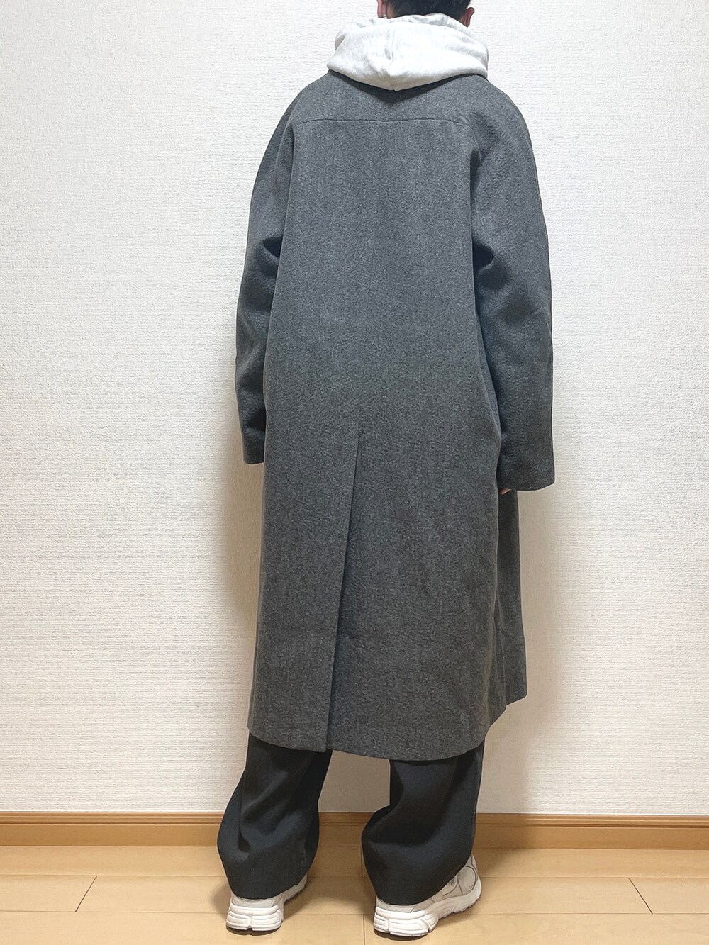 グレー系のステンカラーコート、グレー系のパーカー、ブラック系のTシャツ/カットソーを着用したメンズの冬コーディネートの4枚目の写真