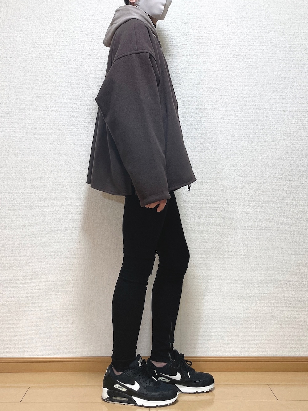 レッド系のブルゾン、ブラウン系のパーカー、ブラック系のTシャツ/カットソーを着用したメンズの冬コーディネートの3枚目の写真