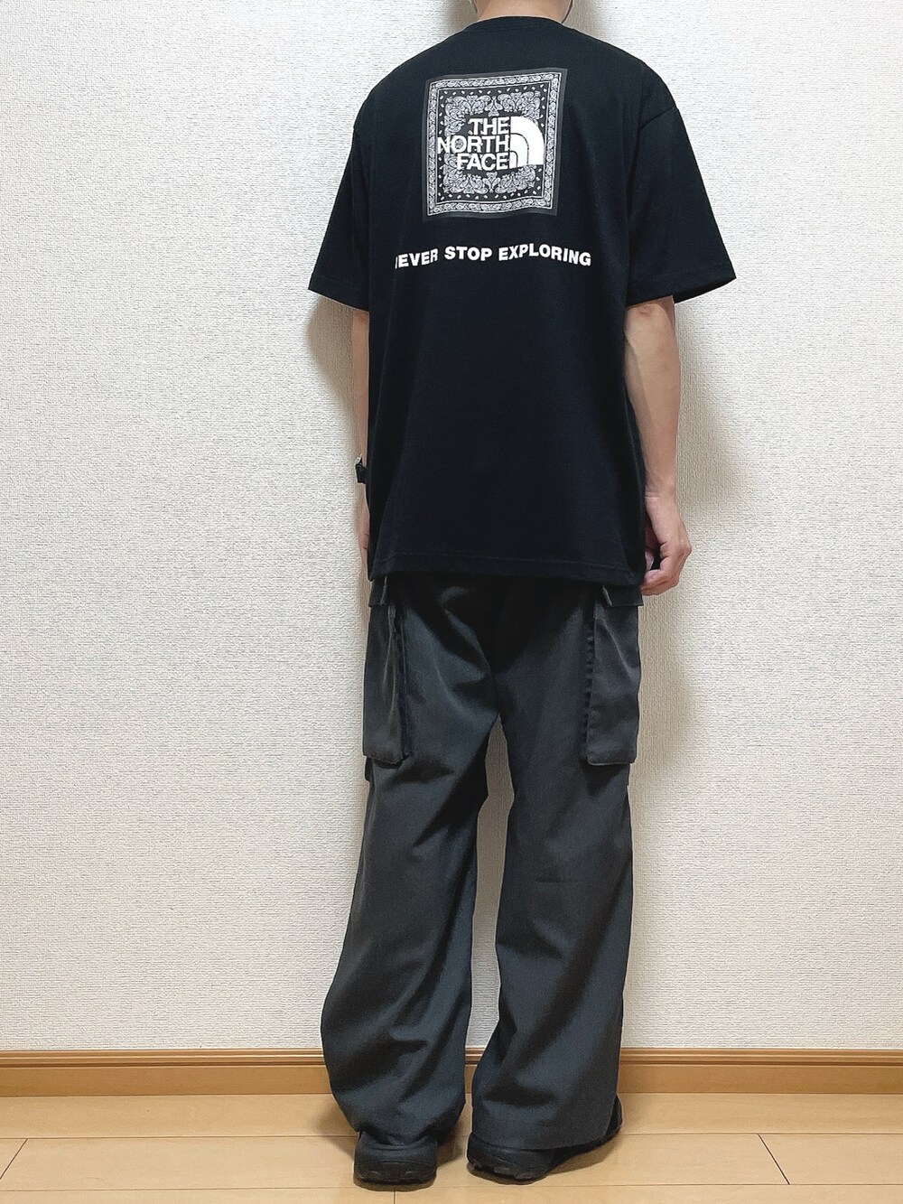 ブラック系のTシャツ/カットソー、グレー系のカーゴパンツ、ブラック系のサンダルを着用したメンズの夏コーディネートの4枚目の写真