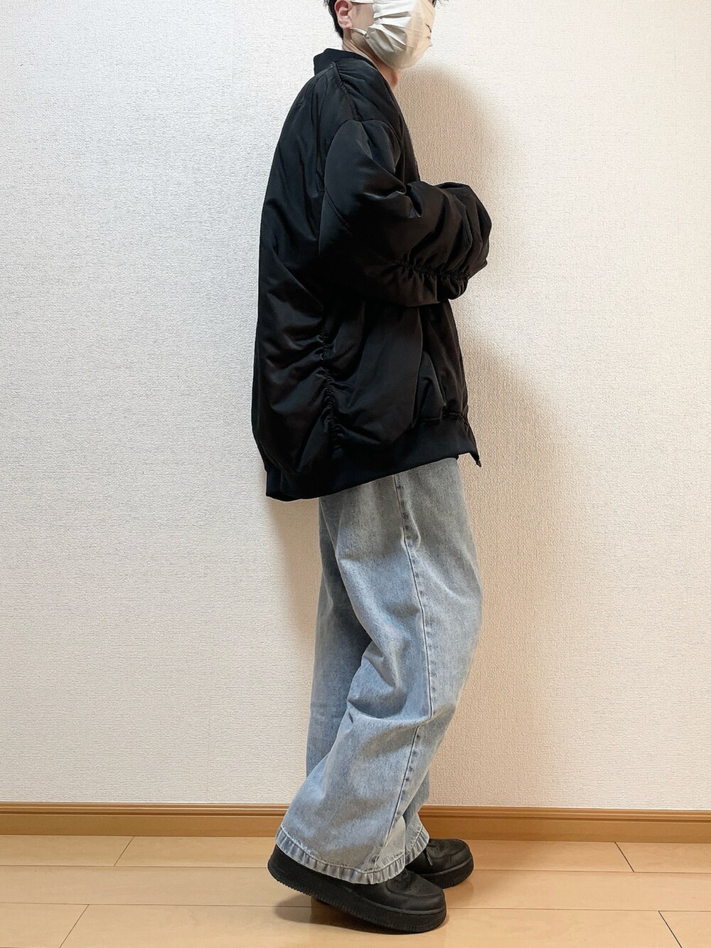 ブラック系のMA-1、ブラック系のスウェット、ブルー系のデニムパンツを着用したメンズの冬コーディネートの2枚目の写真