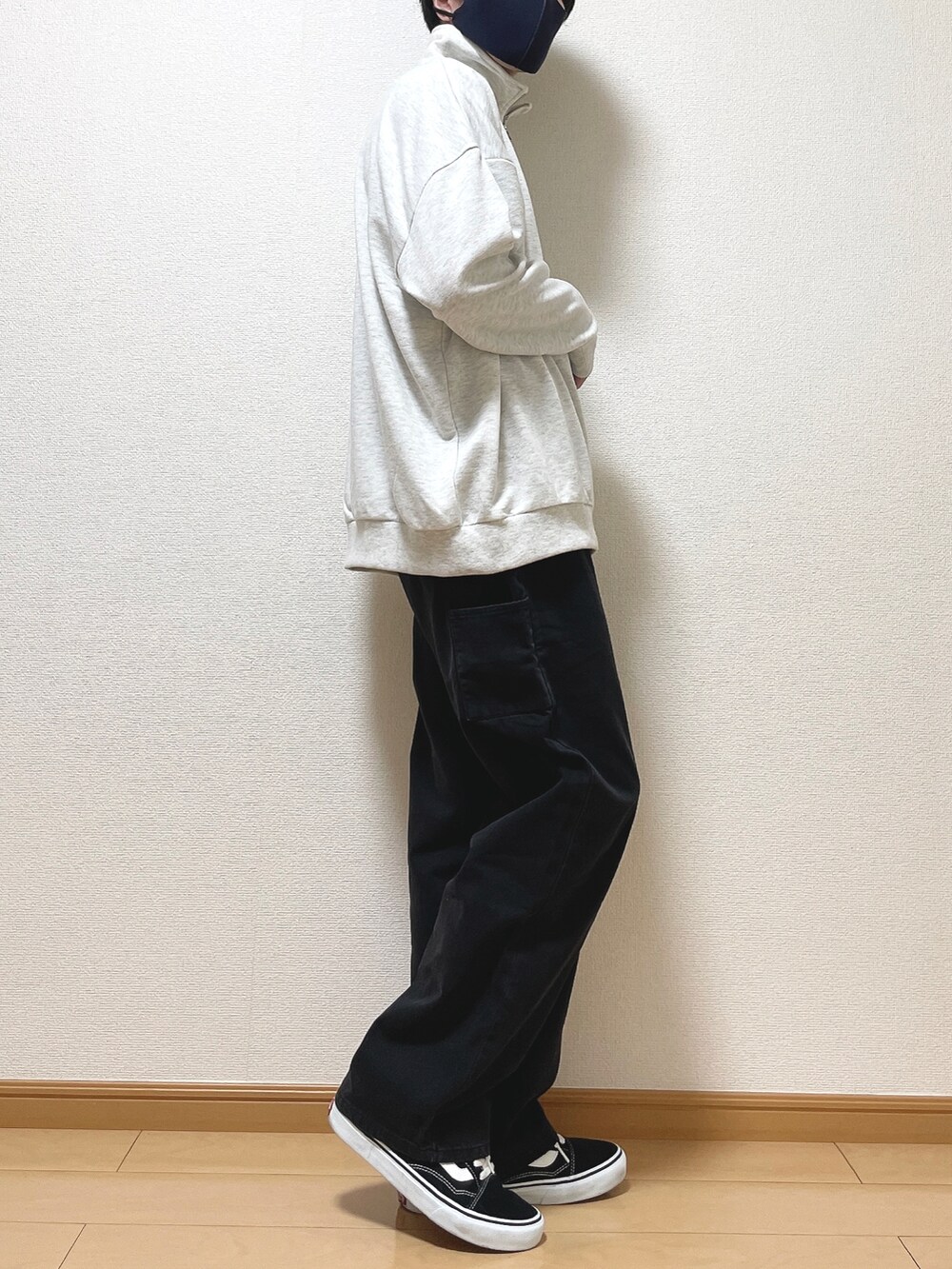 グレー系のスウェット、ブラック系のデニムパンツ、ブラック系のスニーカーを着用したメンズの秋コーディネートの2枚目の写真
