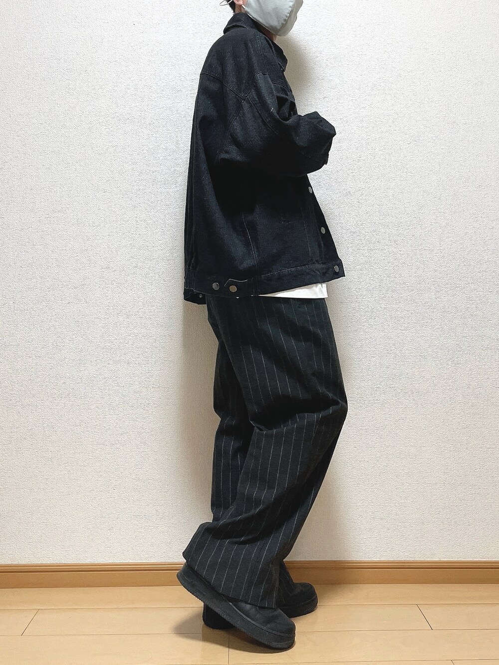 ブラック系のデニムジャケット、ホワイト系のTシャツ/カットソー、ブラック系のパンツを着用したメンズの秋コーディネートの2枚目の写真