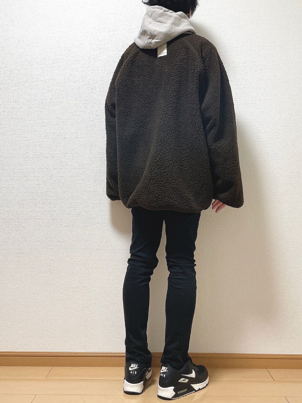 ブラウン系のブルゾン、ベージュ系のパーカー、ブラック系のデニムパンツを着用したメンズの冬コーディネートの4枚目の写真