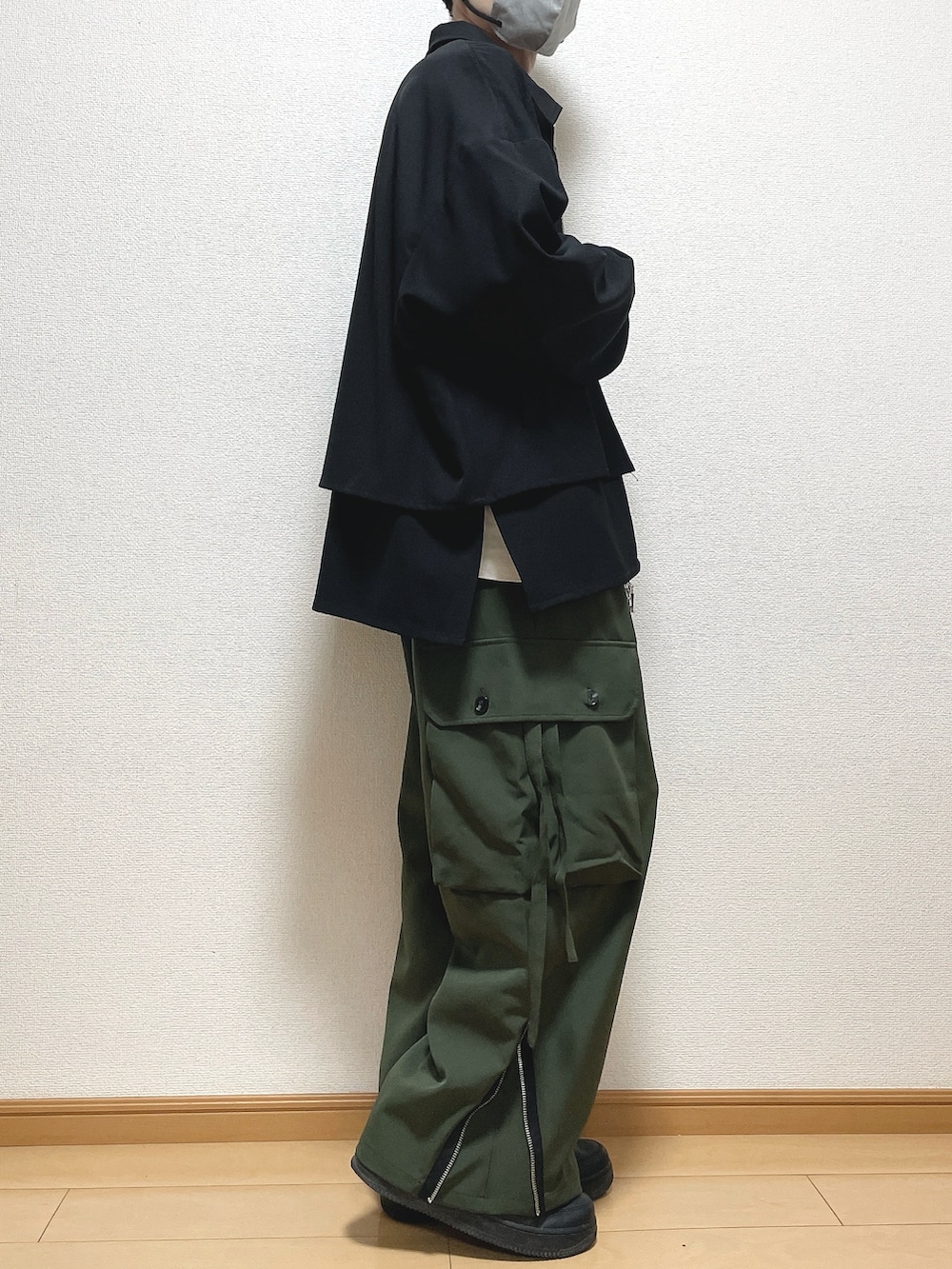 ブラック系のブルゾン、ホワイト系のTシャツ/カットソー、グリーン系のカーゴパンツを着用したメンズの春コーディネートの2枚目の写真