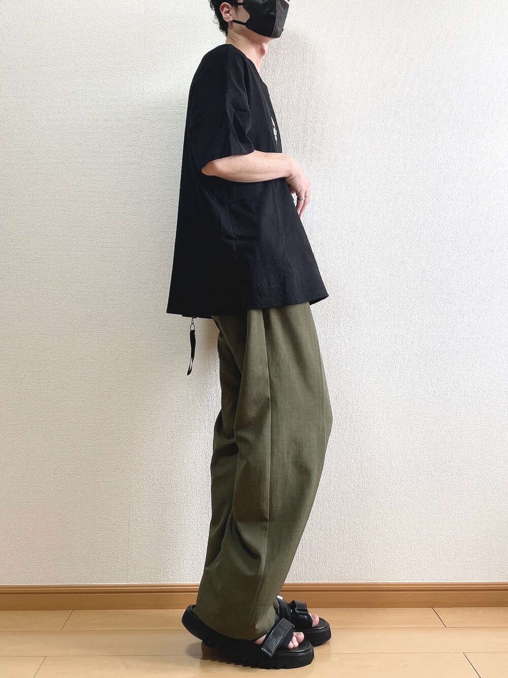 ブラック系のTシャツ/カットソー、グリーン系のその他パンツ、ブラック系のサンダルを着用したメンズの夏コーディネートの2枚目の写真