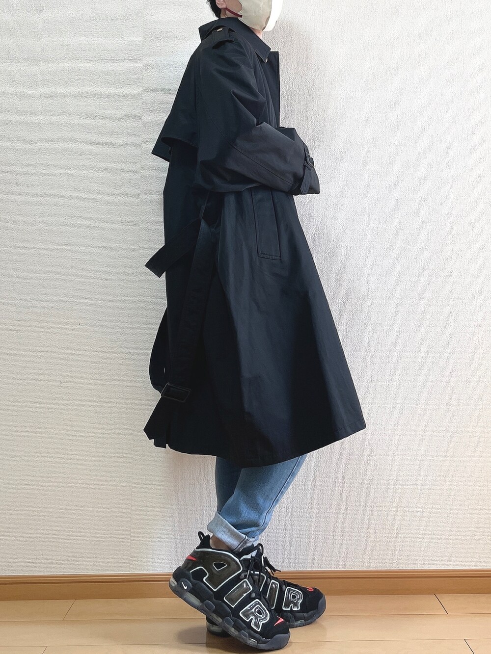 ブラック系のトレンチコート、ホワイト系のシャツ/ブラウス、ブルー系のデニムパンツを着用したメンズの春コーディネートの2枚目の写真