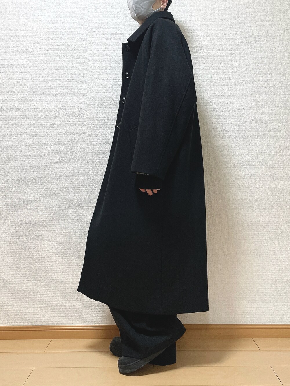 ブラック系のステンカラーコート、ブラック系のニット/セーター、ブラック系のその他パンツを着用したメンズの冬コーディネートの3枚目の写真