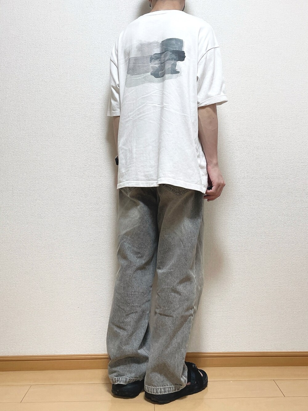 グリーン系のTシャツ/カットソー、ブラック系のデニムパンツ、ブラック系のサンダルを着用したメンズの夏コーディネートの4枚目の写真