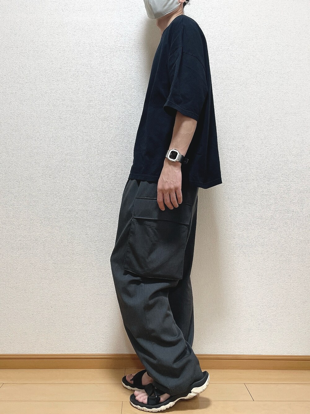 ブラック系のTシャツ/カットソー、グレー系のカーゴパンツ、ブラック系のサンダルを着用したメンズの夏コーディネートの3枚目の写真