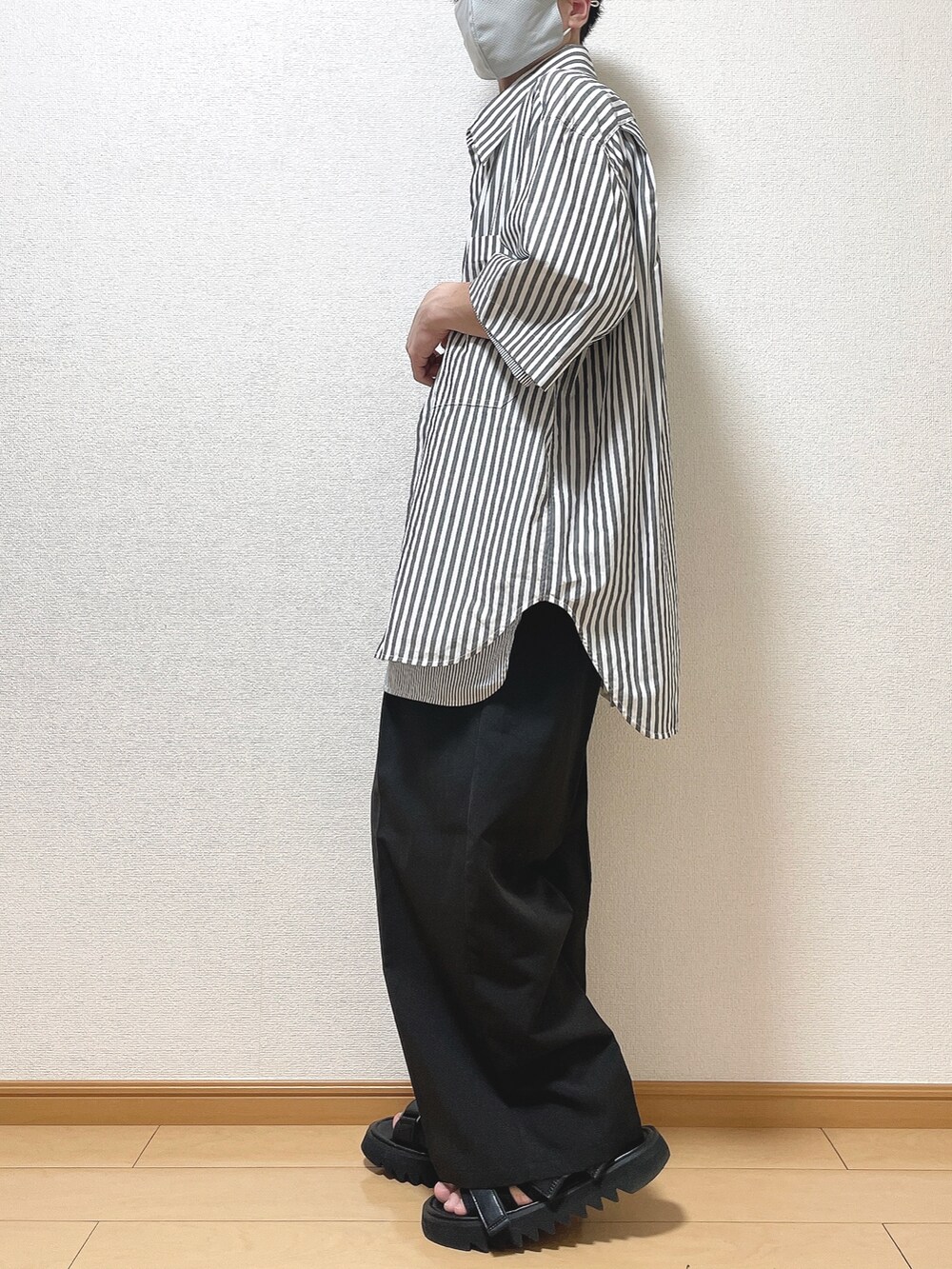 ホワイト系のシャツ/ブラウス、ブラック系のスラックス、ブラック系のサンダルを着用したメンズの夏コーディネートの3枚目の写真
