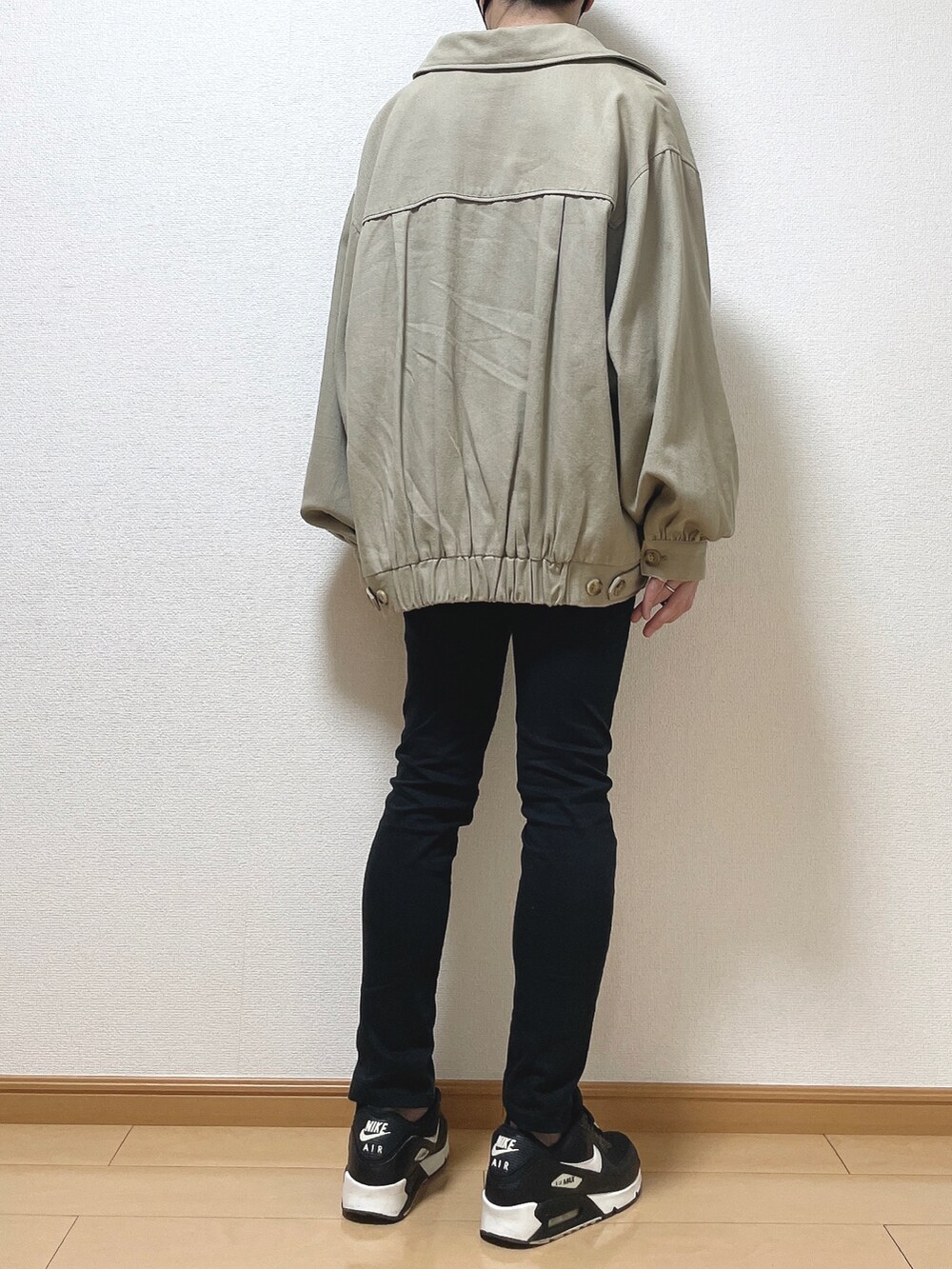 ベージュ系のブルゾン、ホワイト系のTシャツ/カットソー、ブラック系のデニムパンツを着用したメンズの秋コーディネートの4枚目の写真