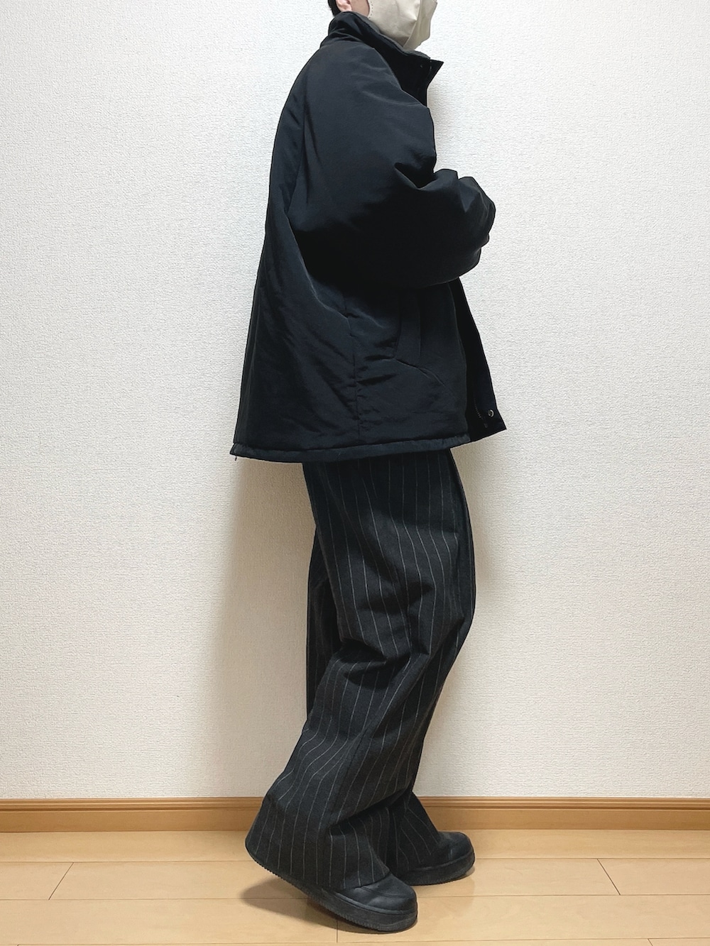 ブラック系のその他アウター、ブラック系のスウェット、ブラック系のパンツを着用したメンズの冬コーディネートの2枚目の写真