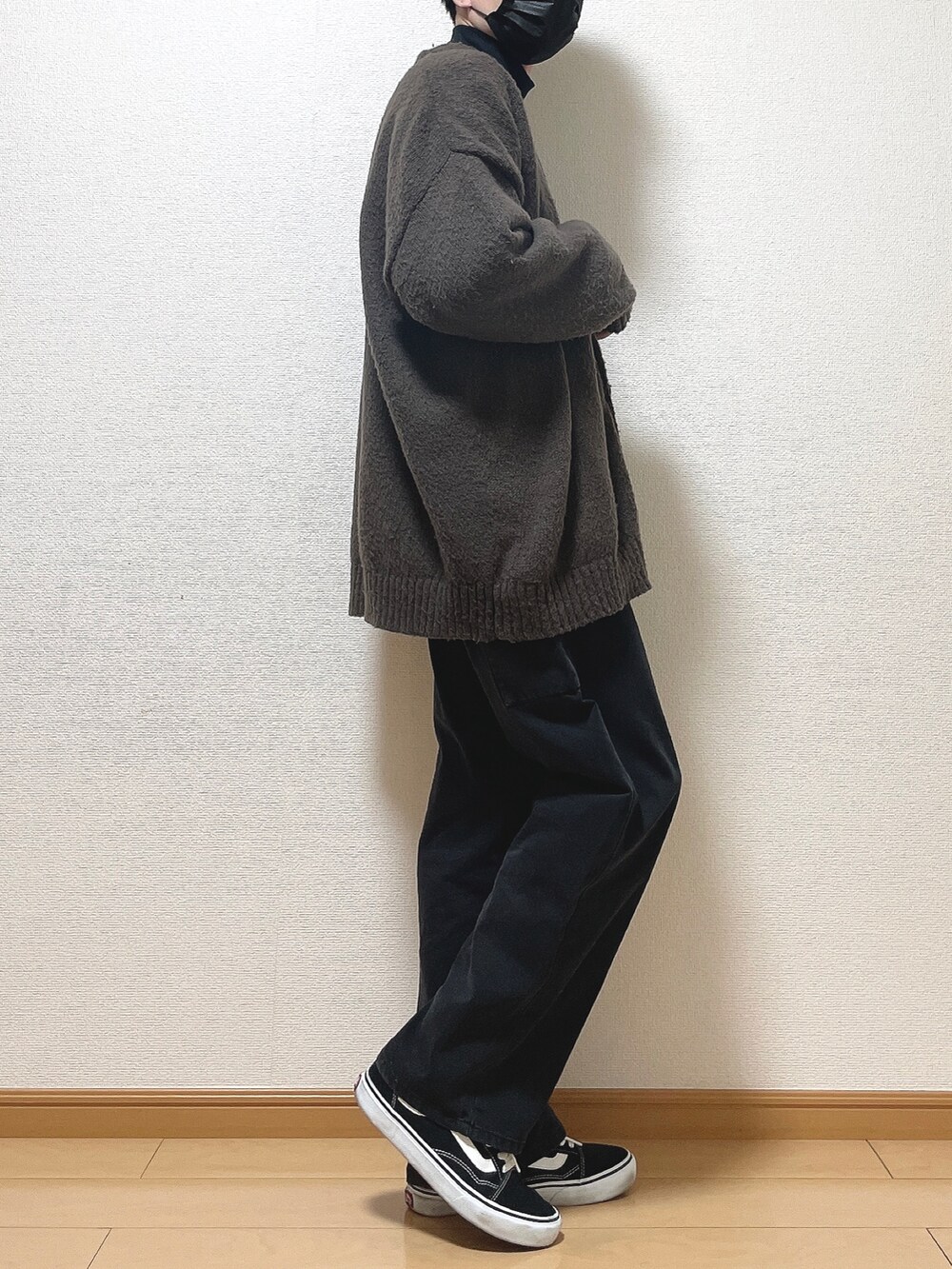 ブラウン系のカーディガン/ボレロ、ブラック系のTシャツ/カットソー、ブラック系のデニムパンツを着用したメンズの冬コーディネートの2枚目の写真