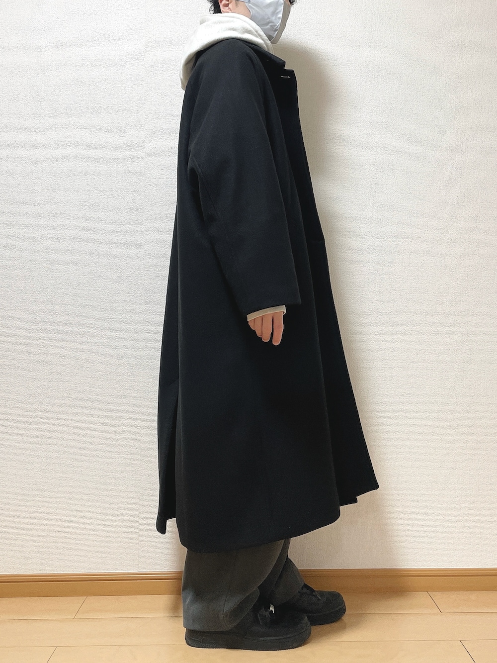ブラック系のステンカラーコート、グレー系のパーカー、グレー系のTシャツ/カットソーを着用したメンズの冬コーディネートの3枚目の写真