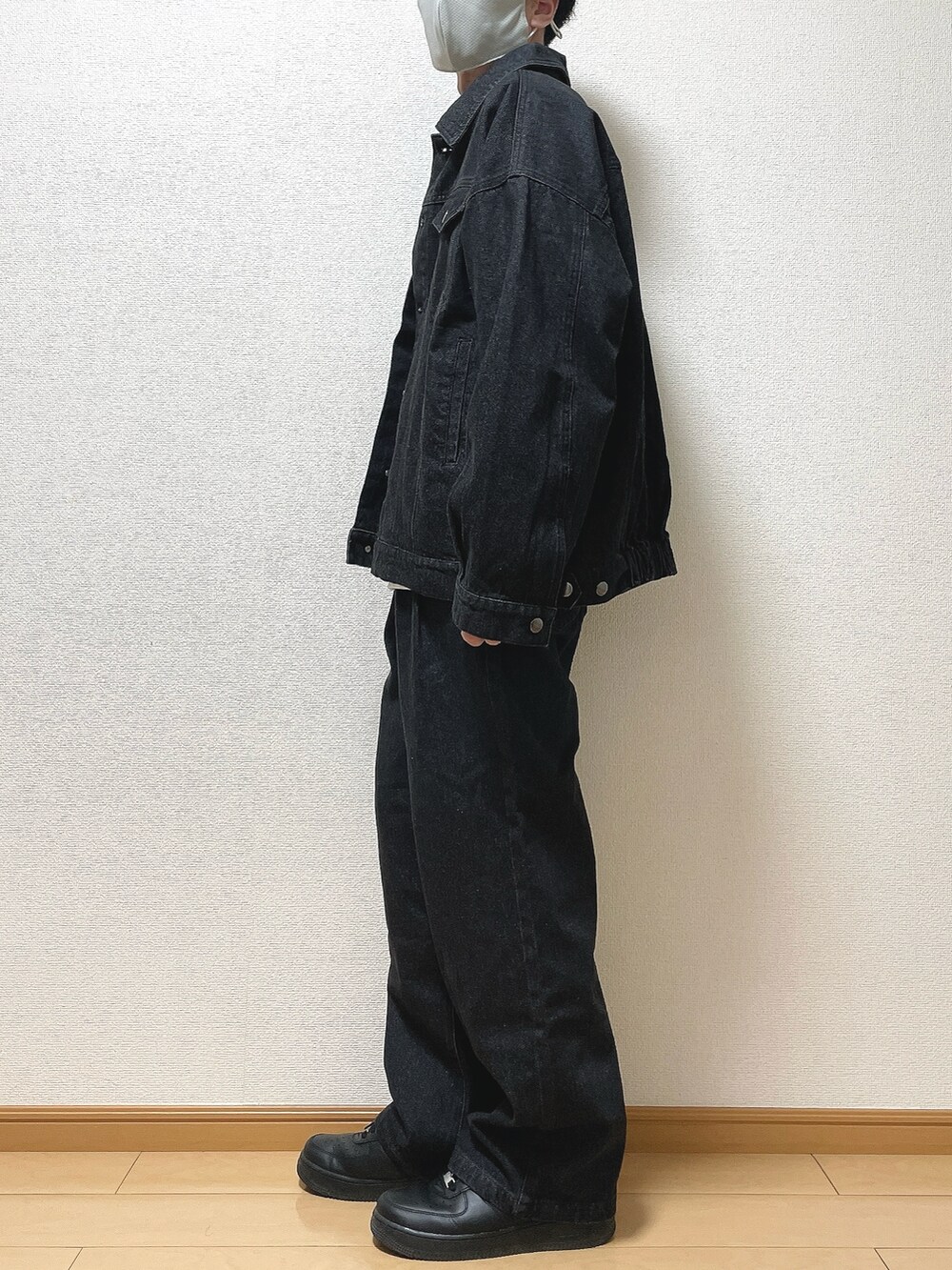 ブラック系のデニムジャケット、ホワイト系のTシャツ/カットソー、ブラック系のデニムパンツを着用したメンズの春コーディネートの3枚目の写真