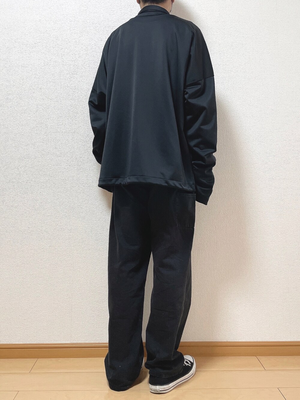 ブラック系のブルゾン、ブルー系のTシャツ/カットソー、ブラック系のデニムパンツを着用したメンズの秋コーディネートの4枚目の写真