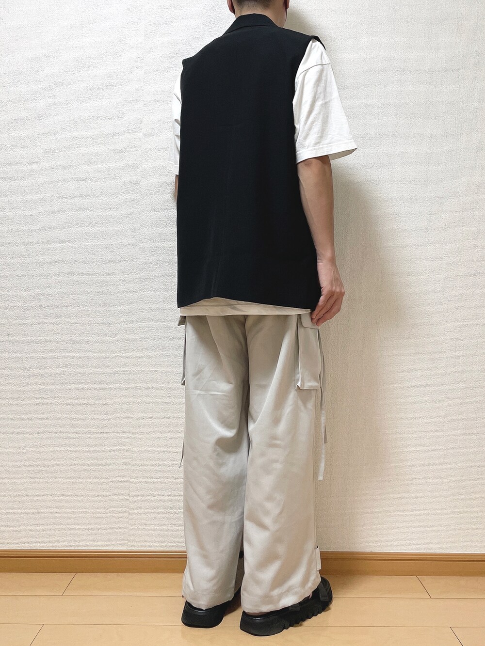 ブラック系のベスト、ホワイト系のTシャツ/カットソー、グレー系のカーゴパンツを着用したメンズの秋コーディネートの4枚目の写真