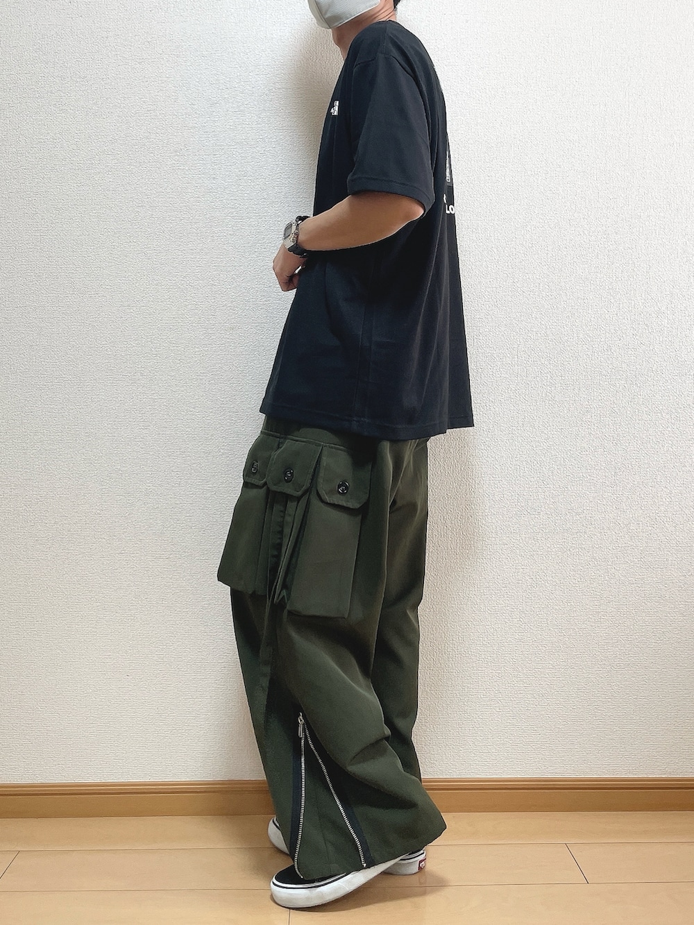 ブラック系のTシャツ/カットソー、グリーン系のカーゴパンツ、ブラック系のスニーカーを着用したメンズの秋コーディネートの3枚目の写真