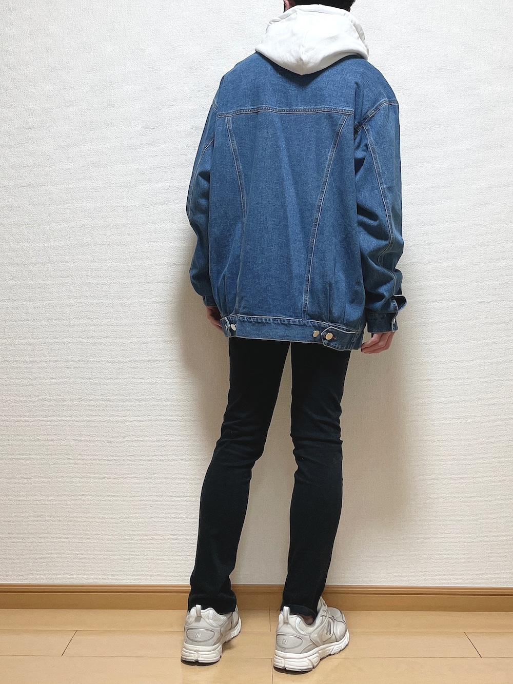 ブルー系のデニムジャケット、ブラック系のデニムパンツ、ホワイト系のスニーカーを着用したメンズの春コーディネートの4枚目の写真