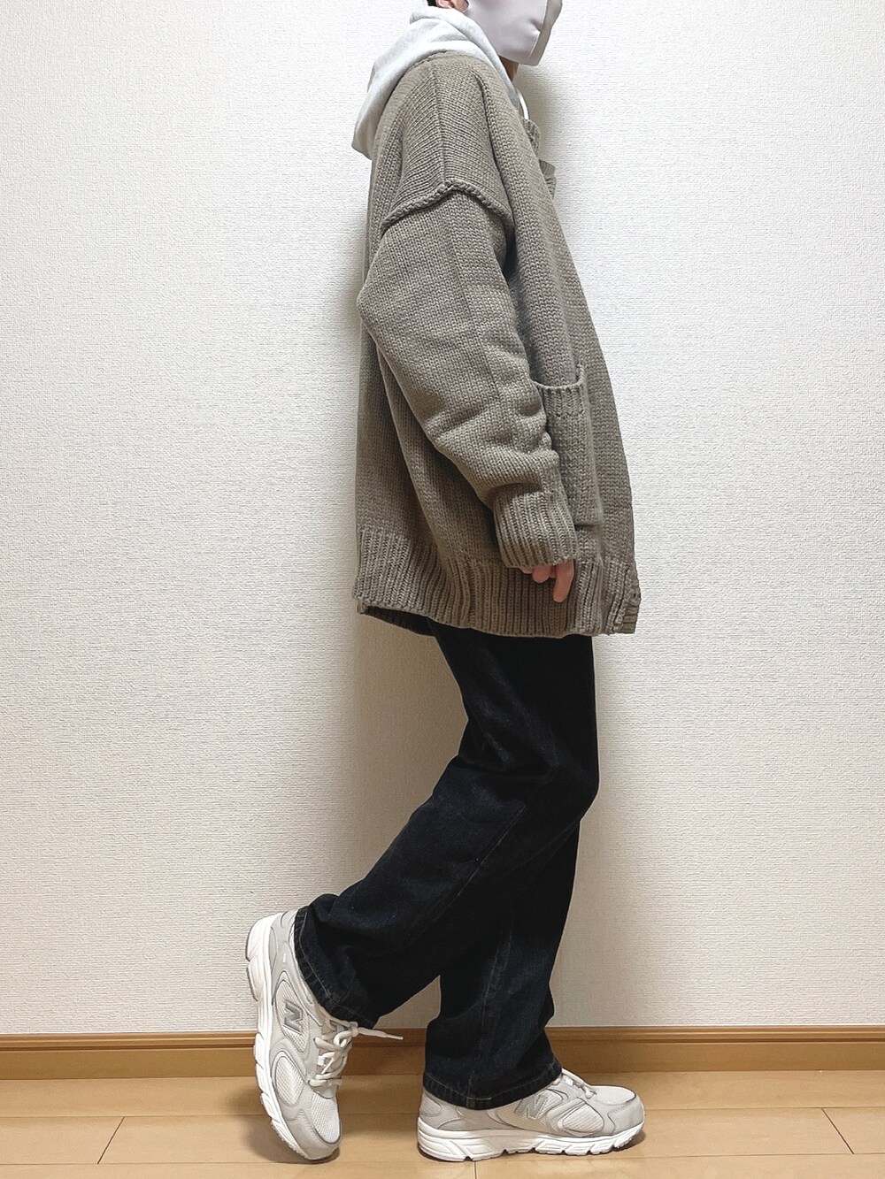 ベージュ系のカーディガン/ボレロ、グレー系のパーカー、ブラック系のデニムパンツを着用したメンズの冬コーディネートの2枚目の写真