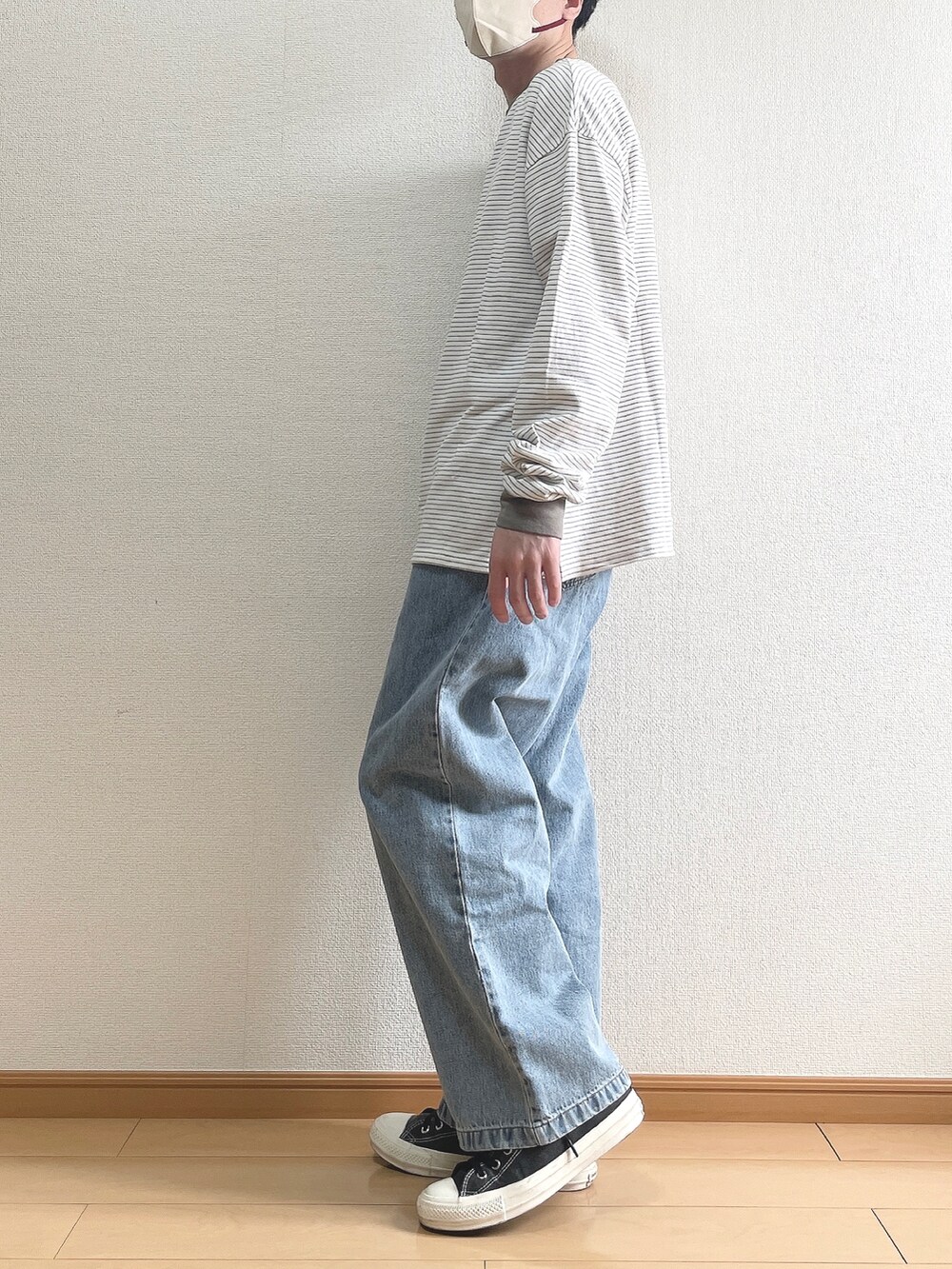 グリーン系のTシャツ/カットソー、ブルー系のデニムパンツ、ブラック系のスニーカーを着用したメンズの春コーディネートの3枚目の写真