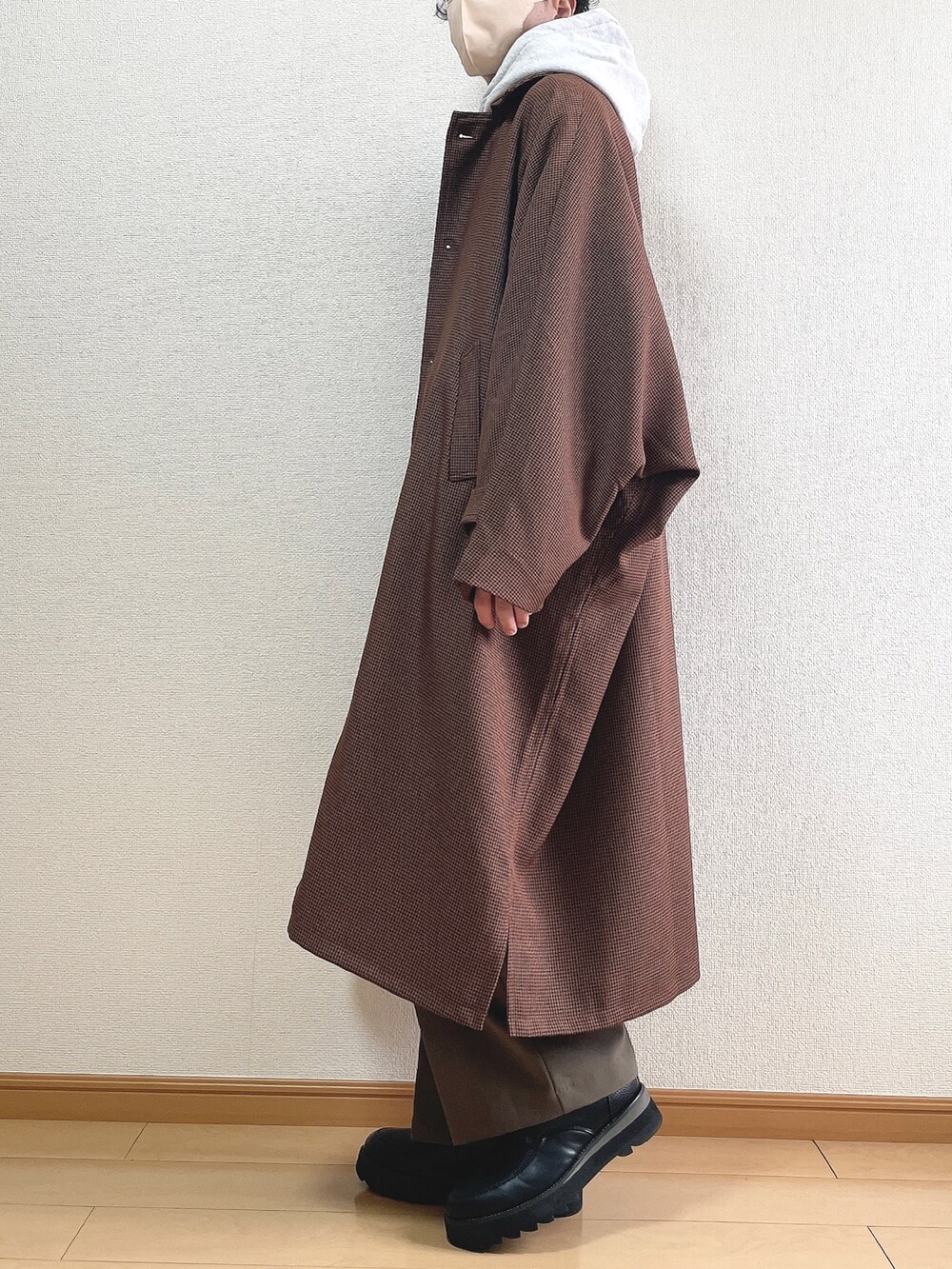 ブラウン系のステンカラーコート、グレー系のパーカー、ブラック系のTシャツ/カットソーを着用したメンズの冬コーディネートの3枚目の写真