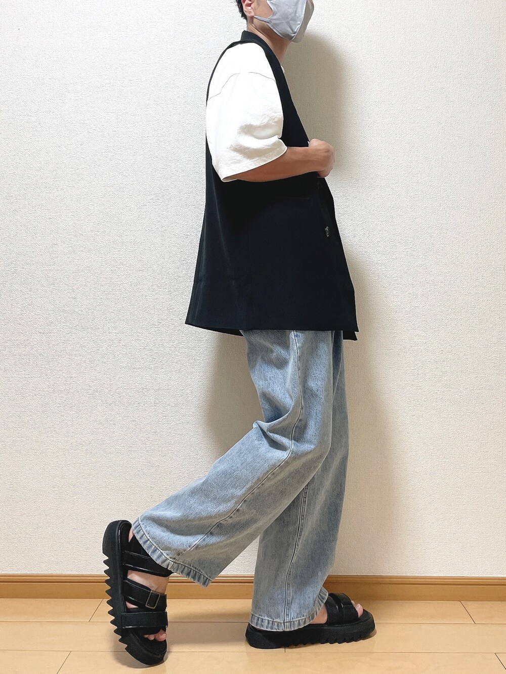 ブラック系のベスト、ホワイト系のTシャツ/カットソー、ブルー系のデニムパンツを着用したメンズの夏コーディネートの2枚目の写真