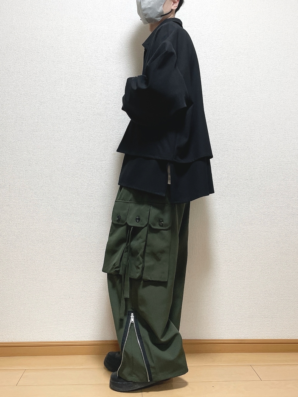ブラック系のブルゾン、ホワイト系のTシャツ/カットソー、グリーン系のカーゴパンツを着用したメンズの春コーディネートの3枚目の写真