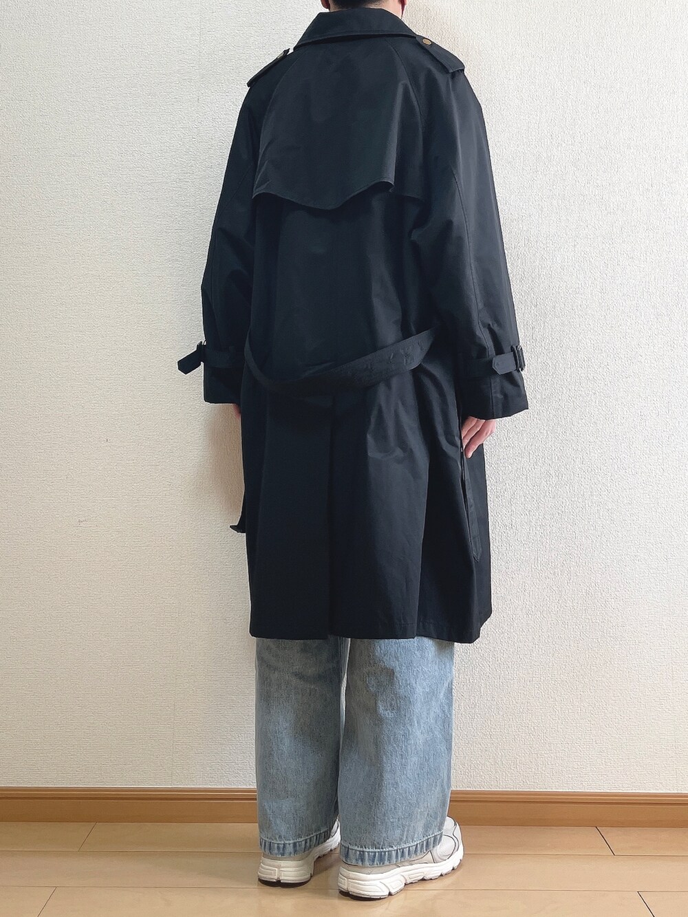 ブラック系のトレンチコート、ベージュ系のニット/セーター、ホワイト系のTシャツ/カットソーを着用したメンズの春コーディネートの4枚目の写真