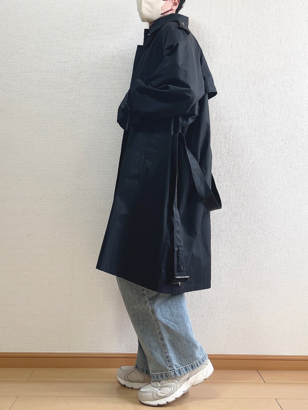 ブラック系のトレンチコート、ベージュ系のニット/セーター、ホワイト系のTシャツ/カットソーを着用したメンズの春コーディネートの3枚目の写真