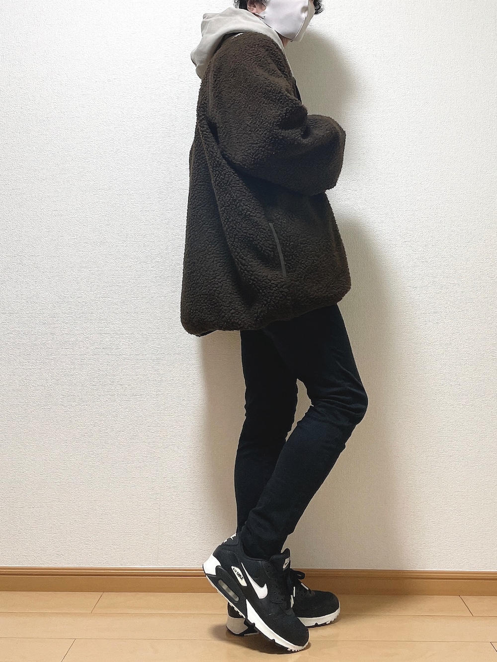 ブラウン系のブルゾン、ベージュ系のパーカー、ブラック系のデニムパンツを着用したメンズの冬コーディネートの2枚目の写真