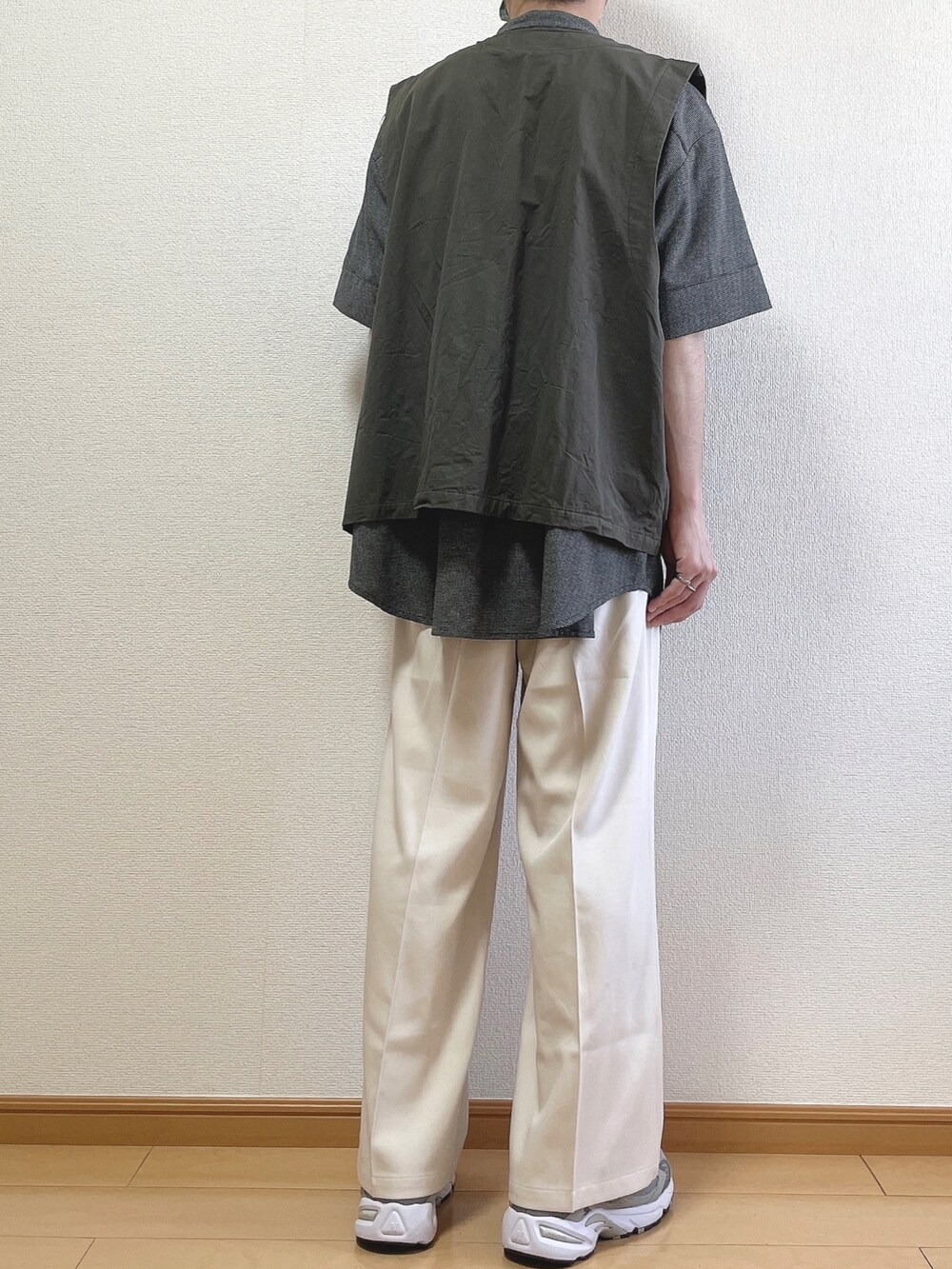 ブラック系のシャツ/ブラウス、グレー系のベスト、ベージュ系のスラックスを着用したメンズの春コーディネートの4枚目の写真