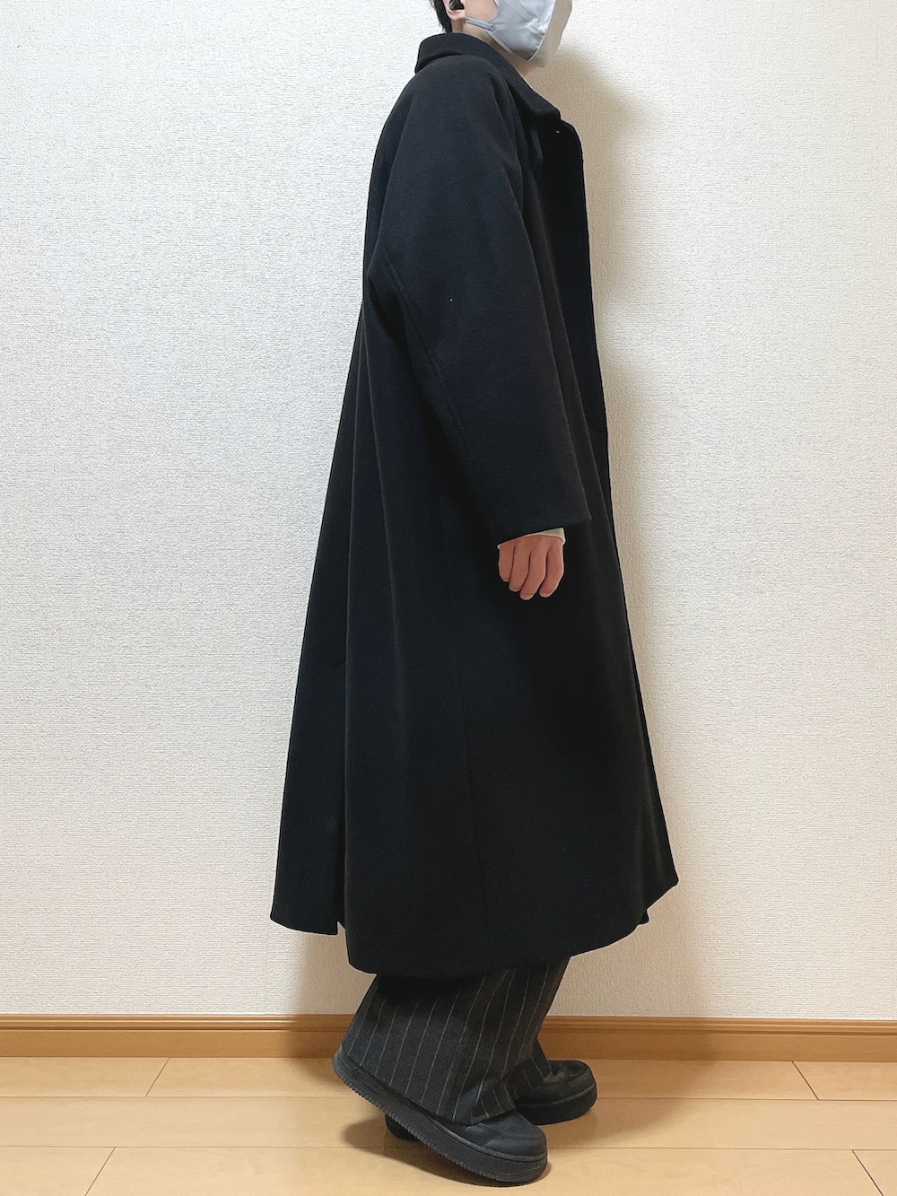 ブラック系のステンカラーコート、グレー系のスウェット、ブラック系のパンツを着用したメンズの冬コーディネートの2枚目の写真