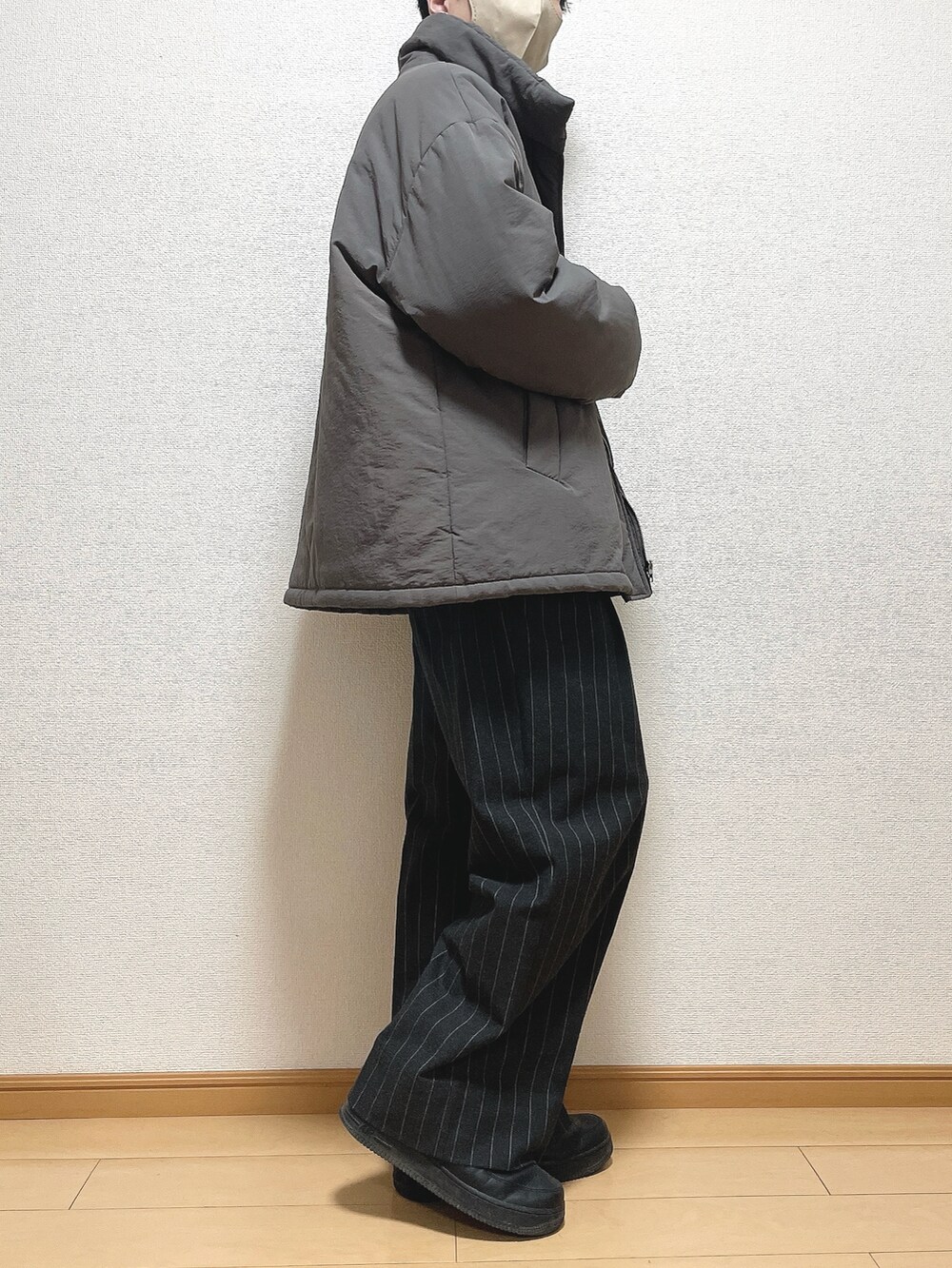 ブラウン系のその他アウター、ブラック系のニット/セーター、ブラック系のパンツを着用したメンズの冬コーディネートの3枚目の写真