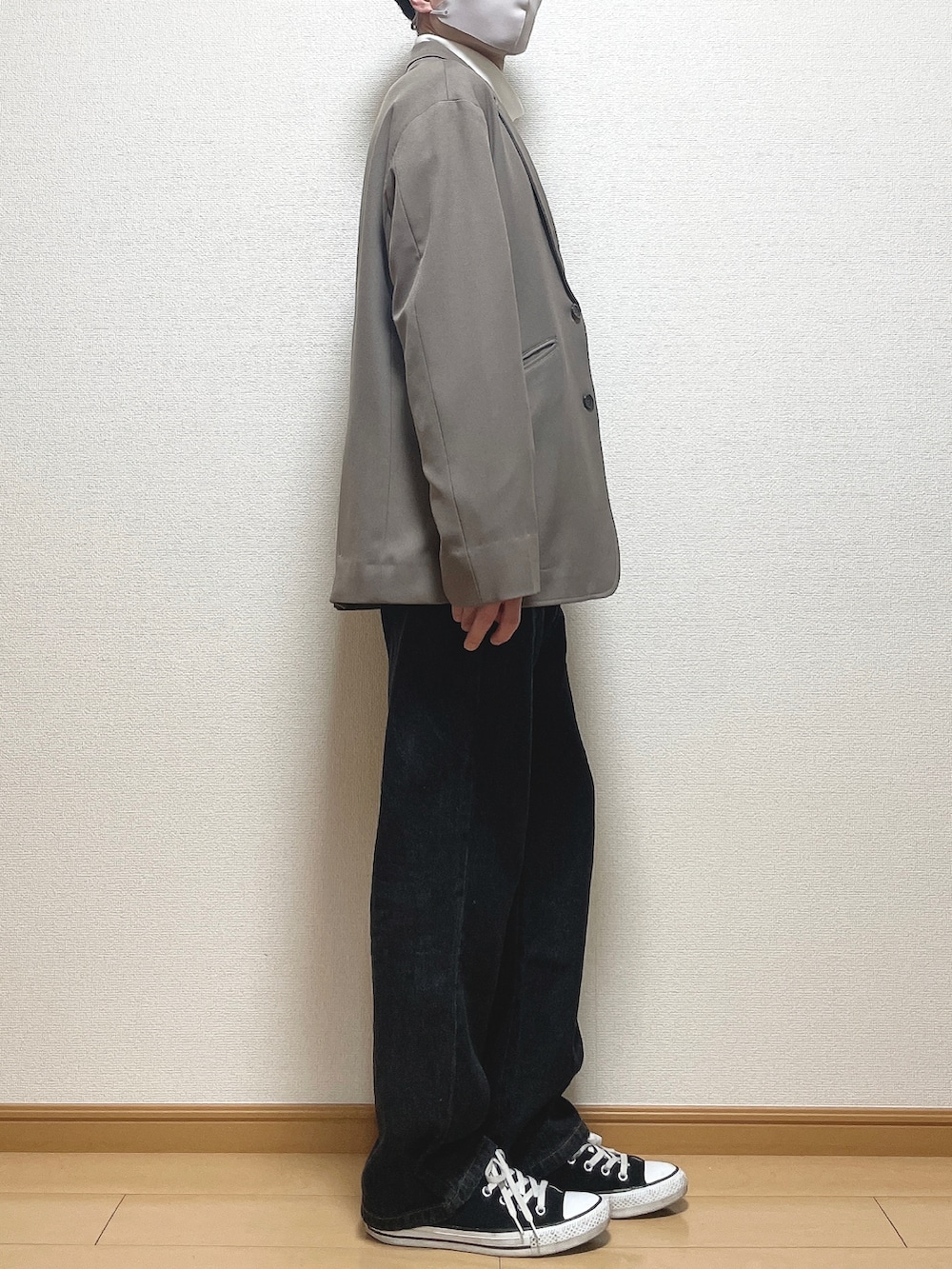 ベージュ系のセットアップ、ホワイト系のTシャツ/カットソー、ブラック系のデニムパンツを着用したメンズの春コーディネートの2枚目の写真