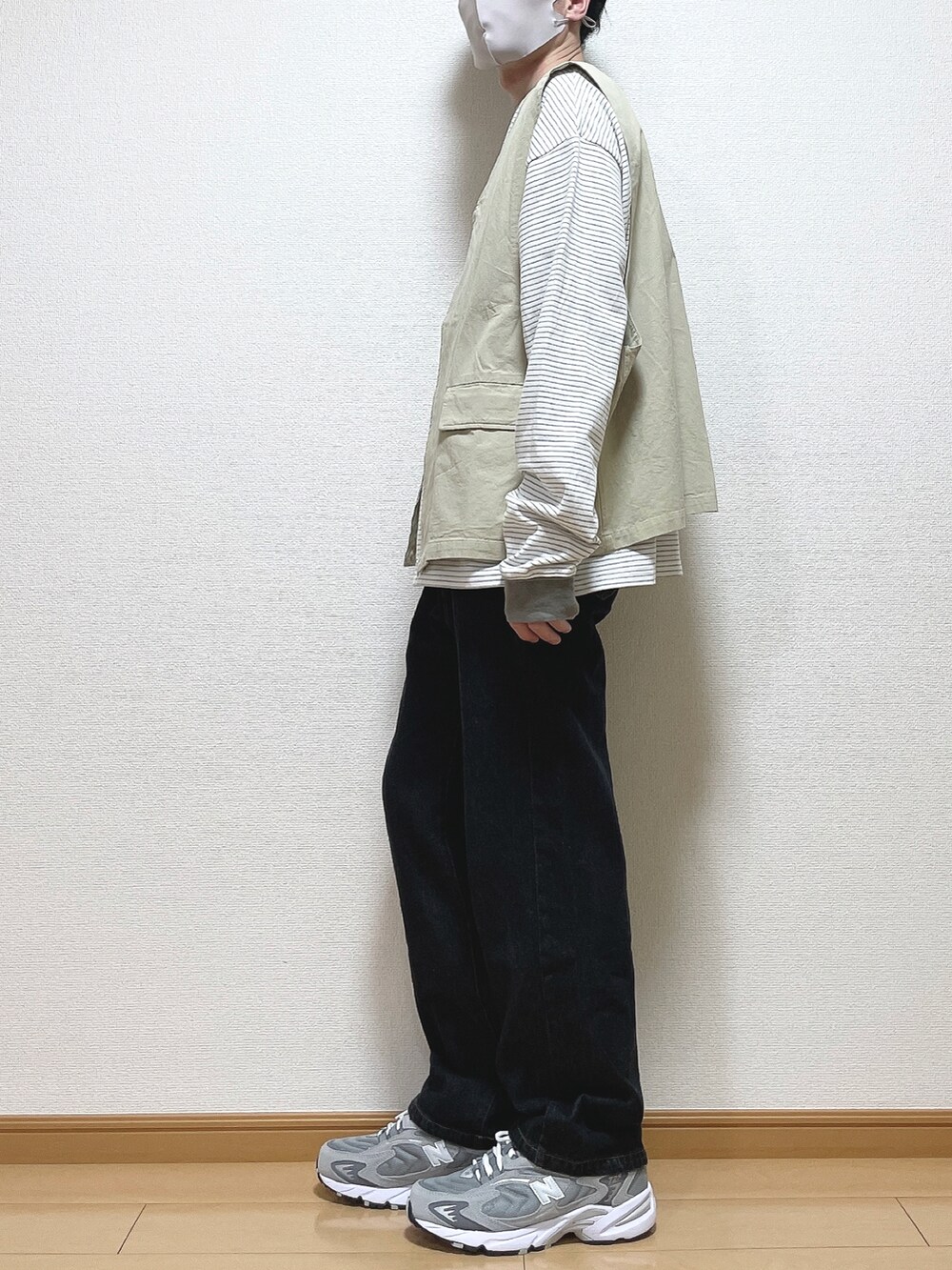 グリーン系のTシャツ/カットソー、ブラック系のデニムパンツ、グレー系のスニーカーを着用したメンズの春コーディネートの3枚目の写真