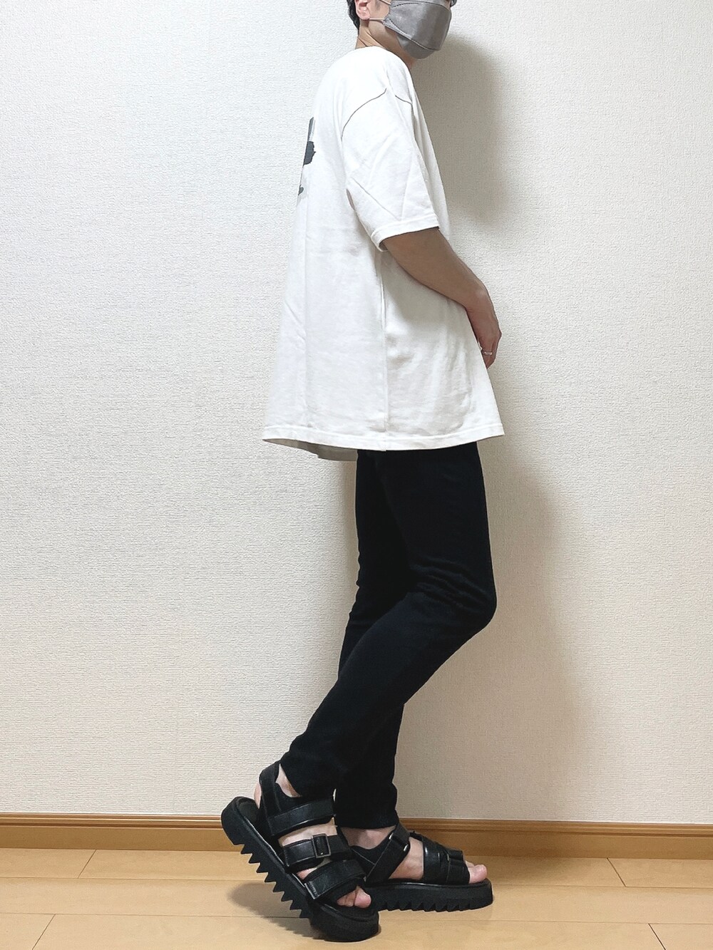 グリーン系のTシャツ/カットソー、ブラック系のデニムパンツ、ブラック系のサンダルを着用したメンズの夏コーディネートの3枚目の写真