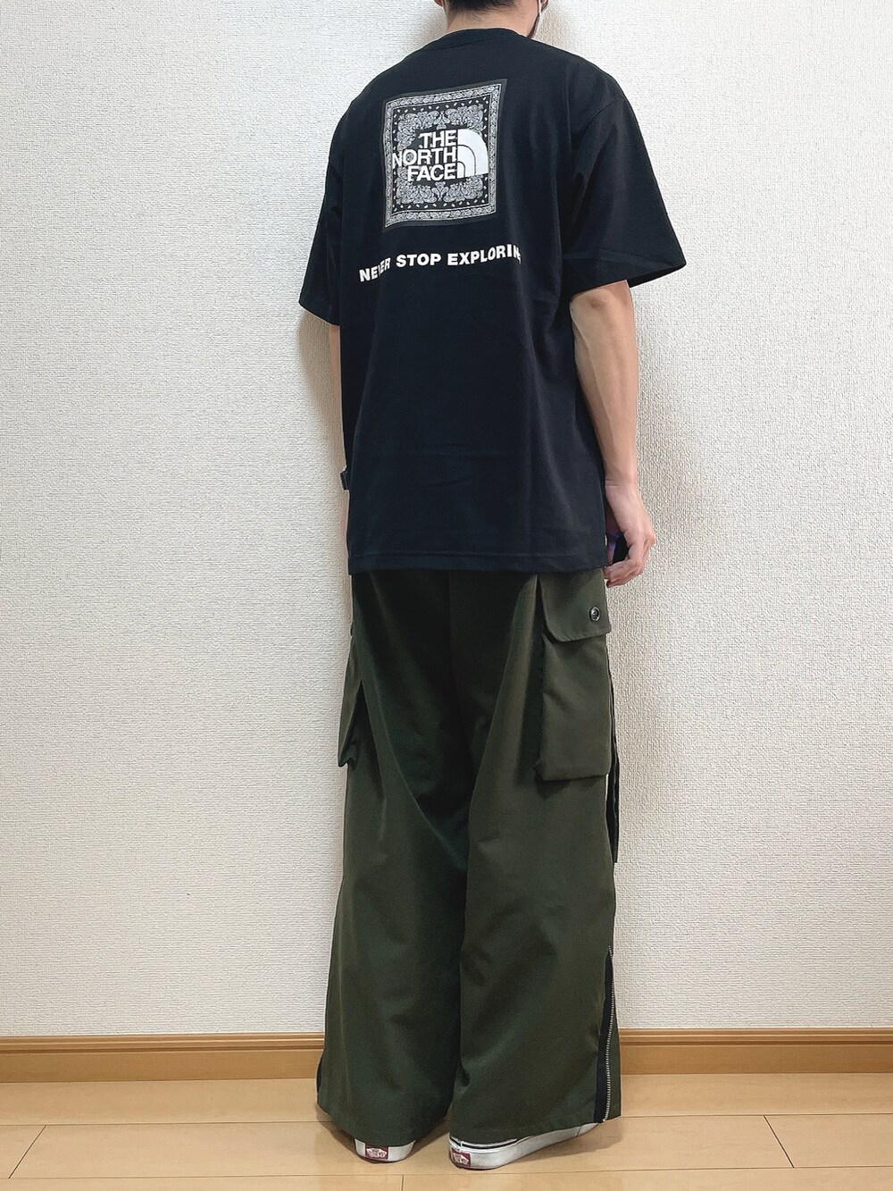 ブラック系のTシャツ/カットソー、グリーン系のカーゴパンツ、ブラック系のスニーカーを着用したメンズの秋コーディネートの4枚目の写真