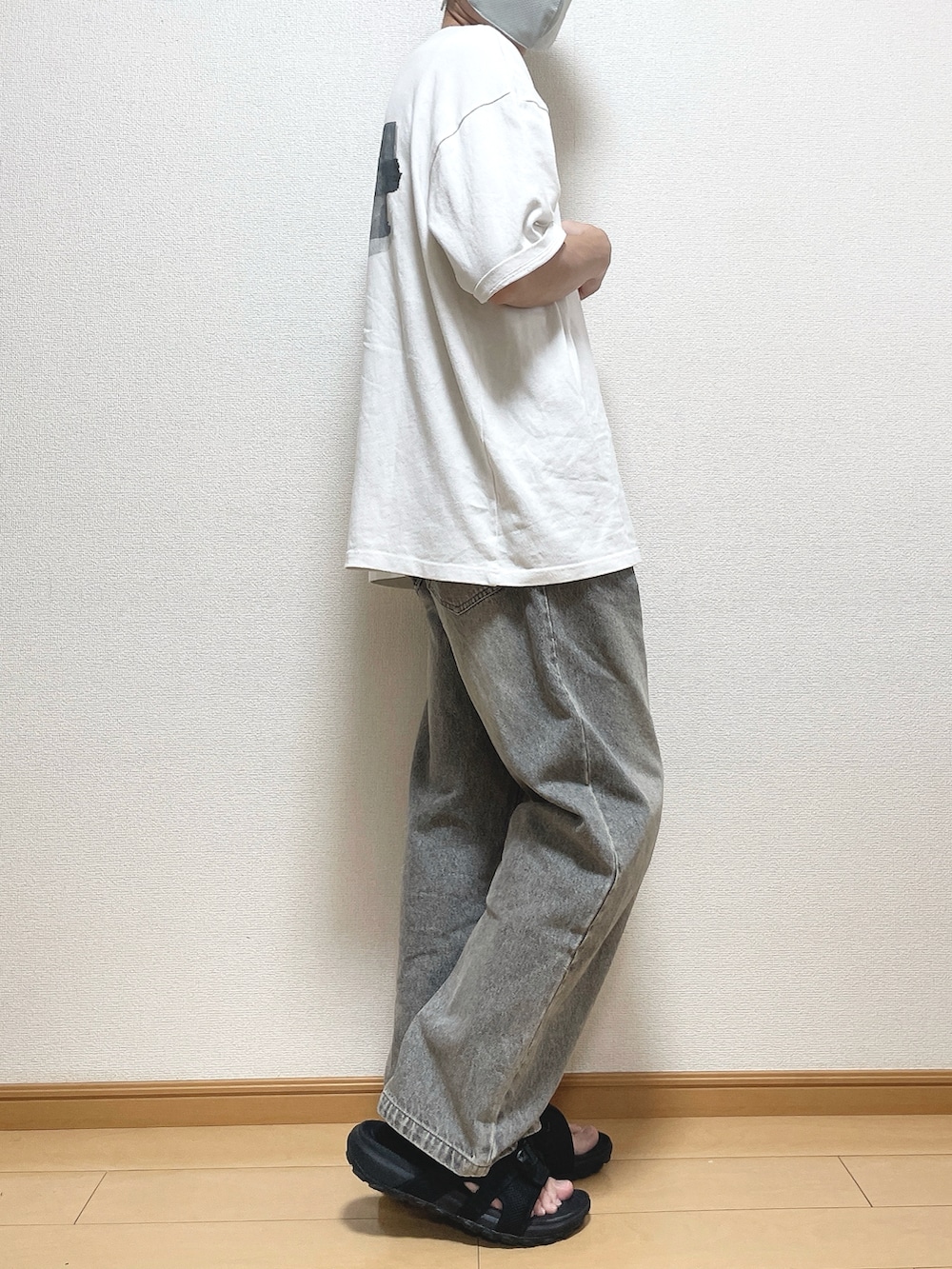 グリーン系のTシャツ/カットソー、ブラック系のデニムパンツ、ブラック系のサンダルを着用したメンズの夏コーディネートの2枚目の写真