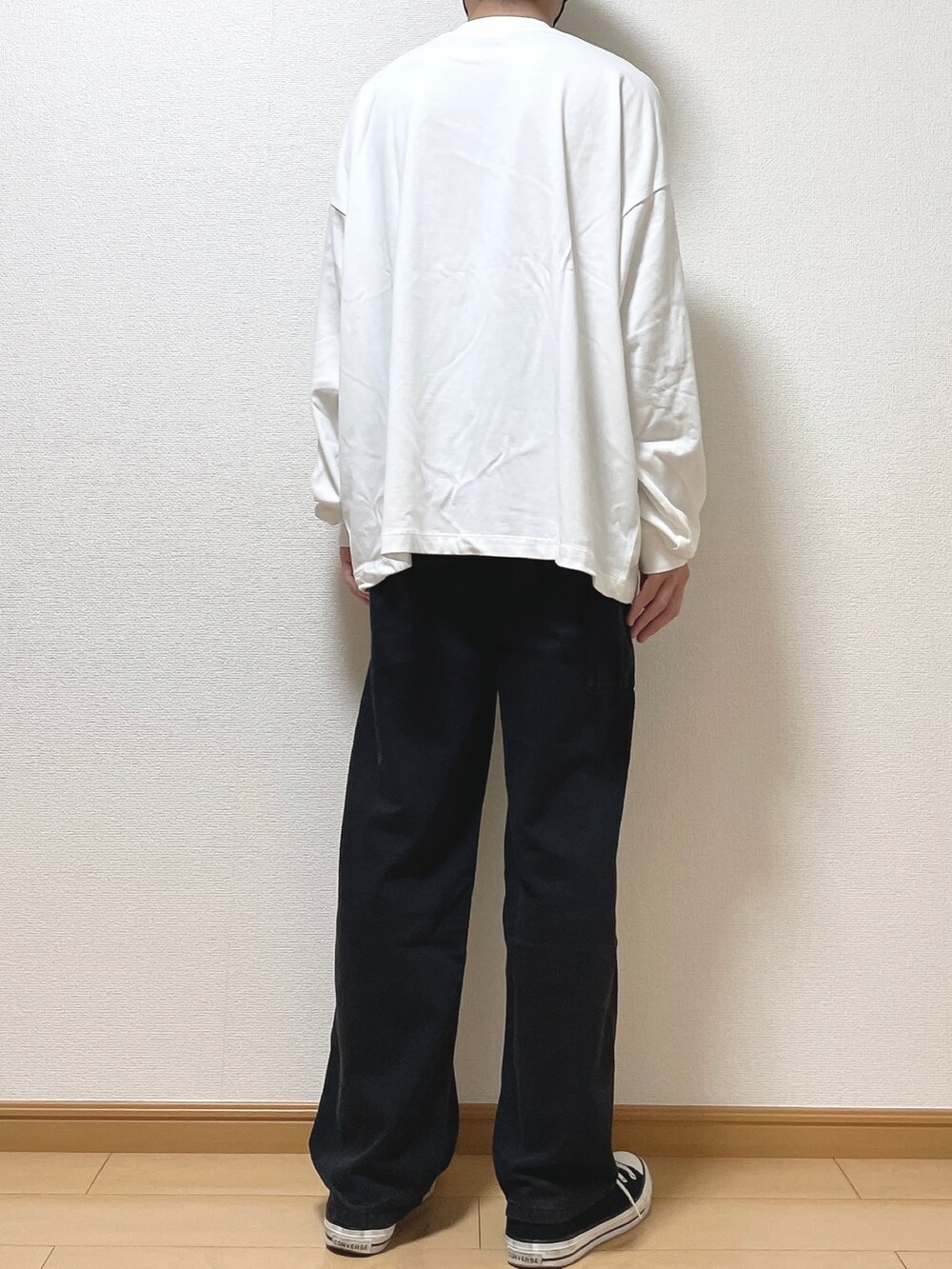 ホワイト系のTシャツ/カットソー、ブラック系のデニムパンツ、ブラック系のスニーカーを着用したメンズの秋コーディネートの4枚目の写真